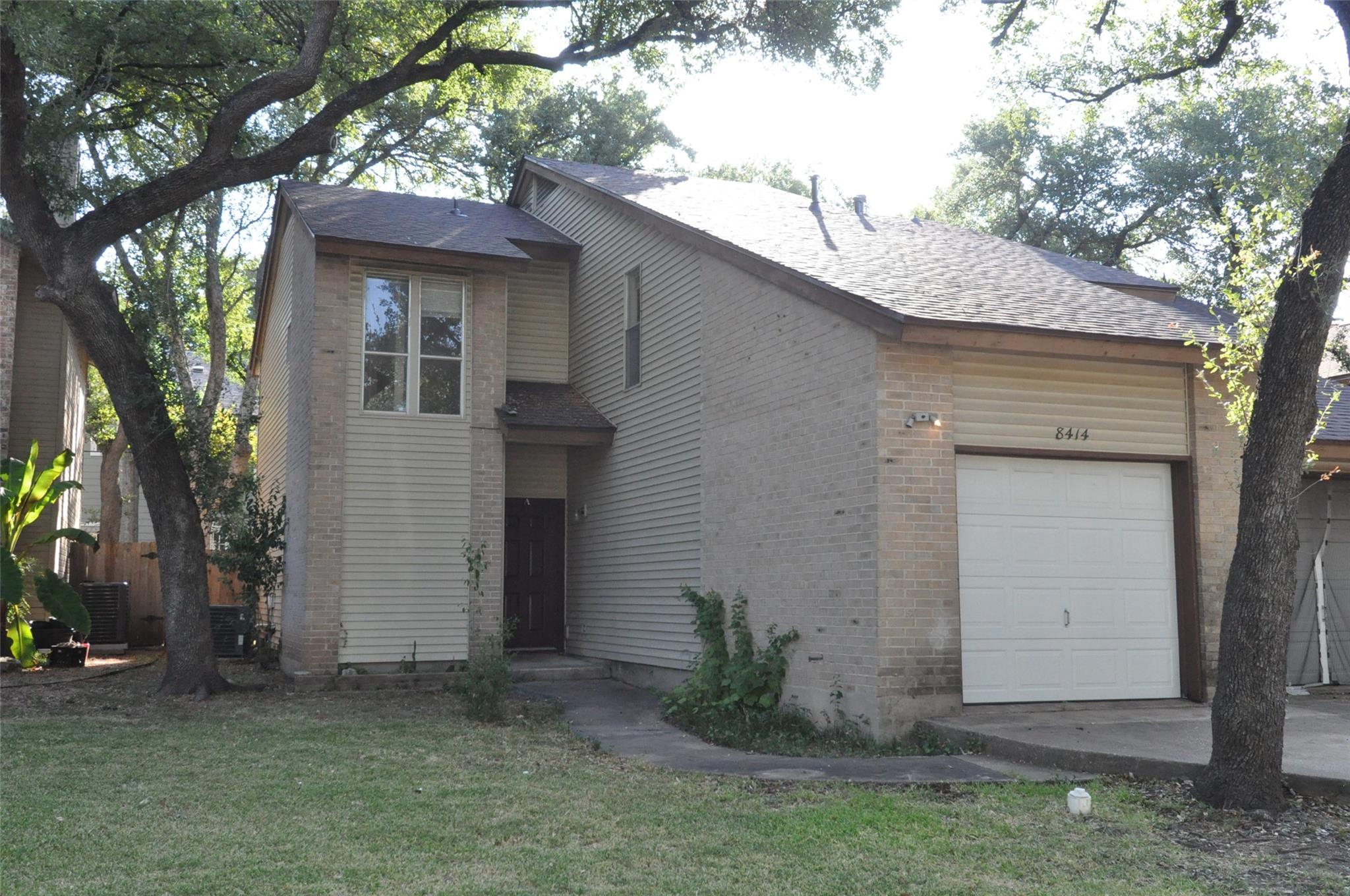 Mature trees shade a classic two-story facade fea