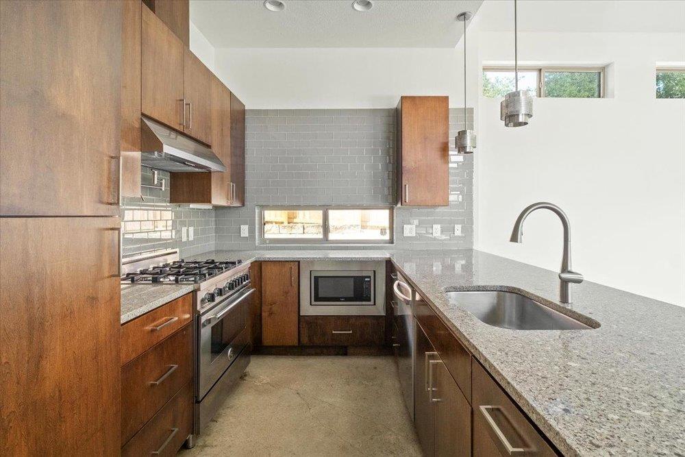 Rich wood cabinetry contrasts beautifully with gr