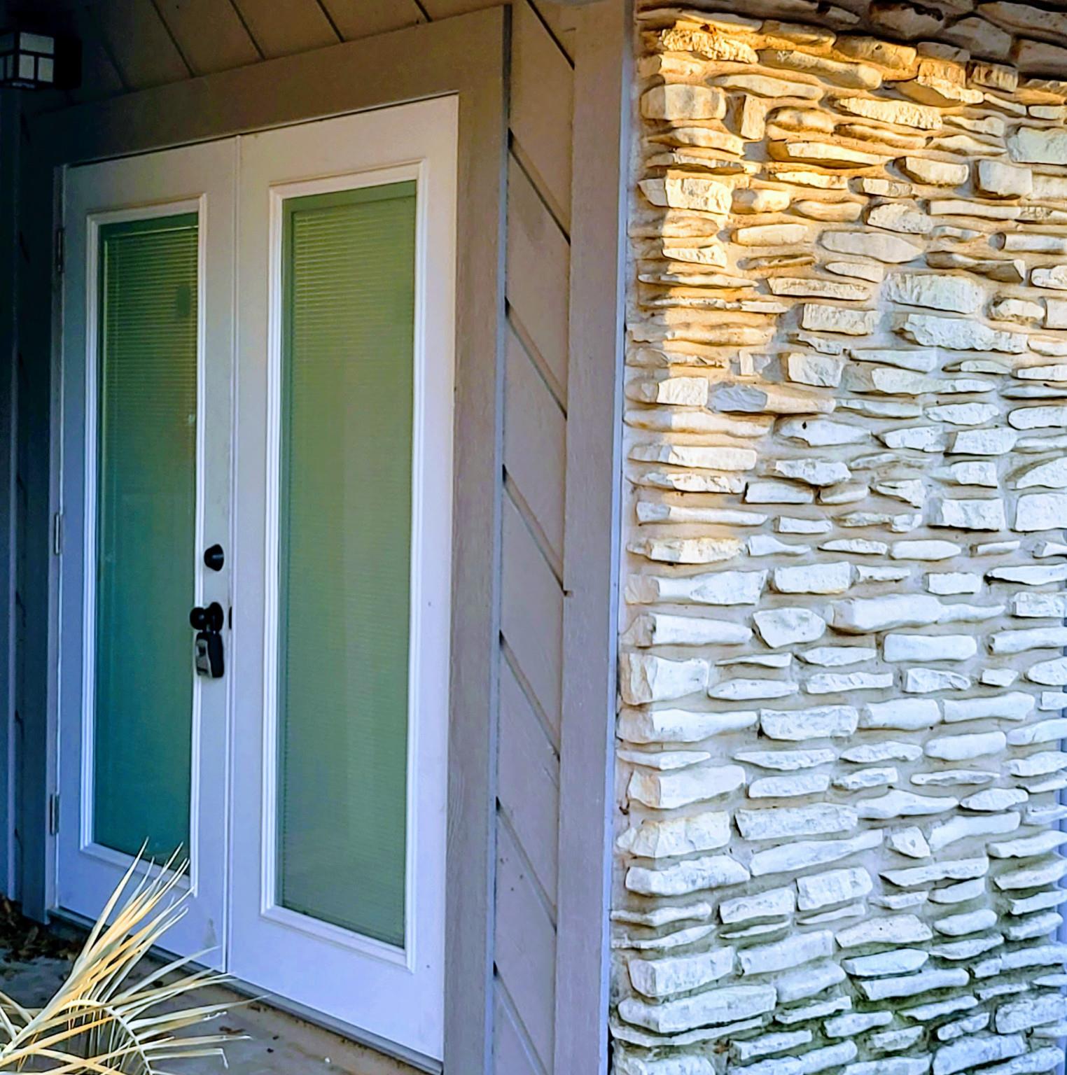 Double glass doors framed by natural stone accent