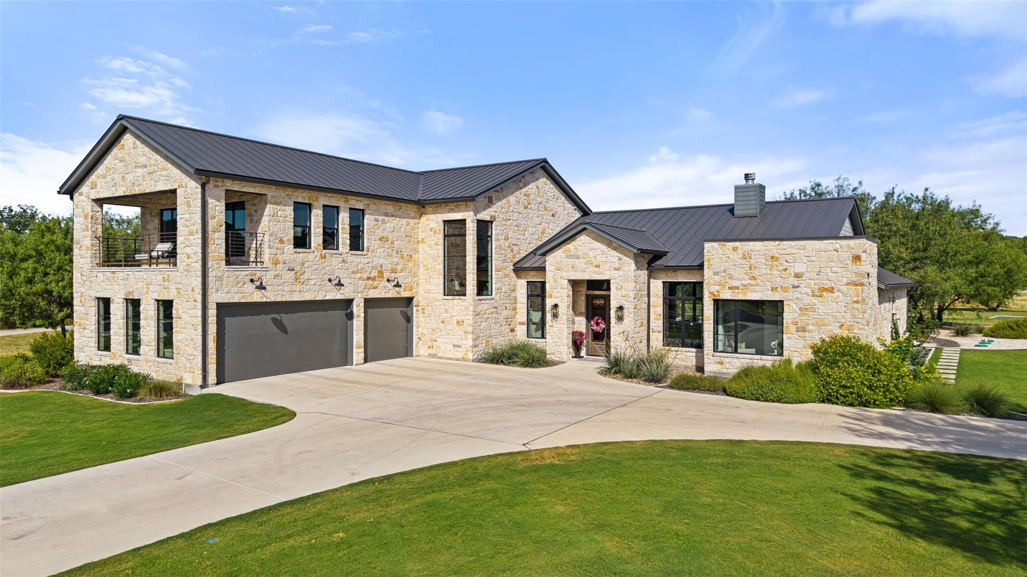 Natural stone masonry and a dark metal roof defin