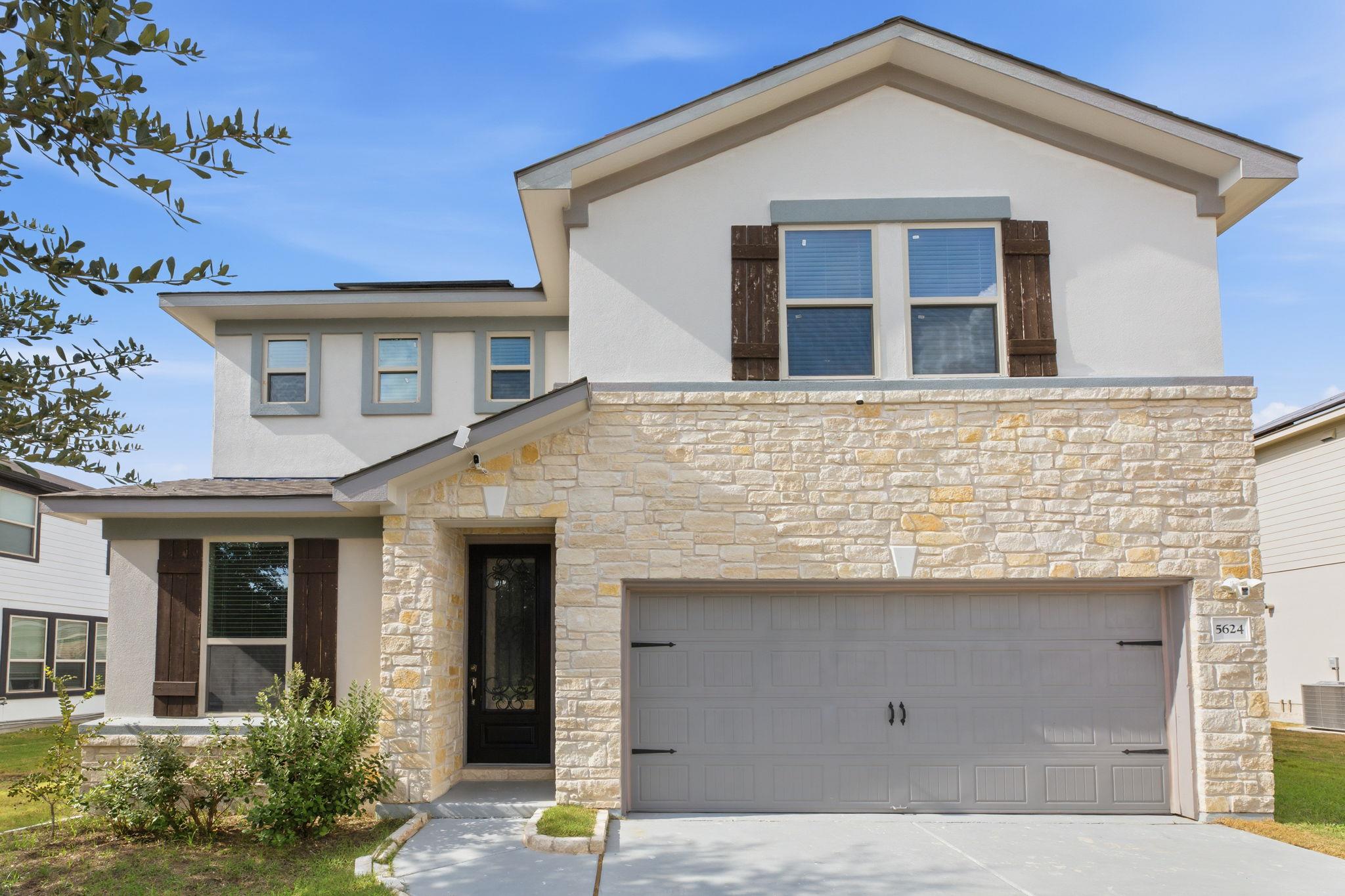 Natural stone accents and dark wood shutters crea