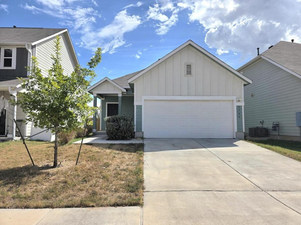 A wide concrete driveway leads up to a spacious a