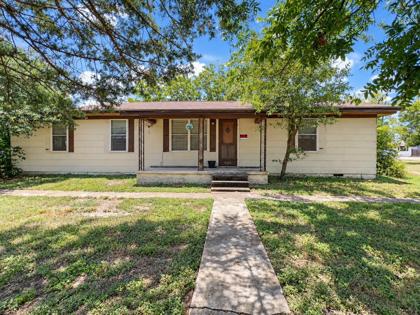 A concrete walkway leads to the covered front por