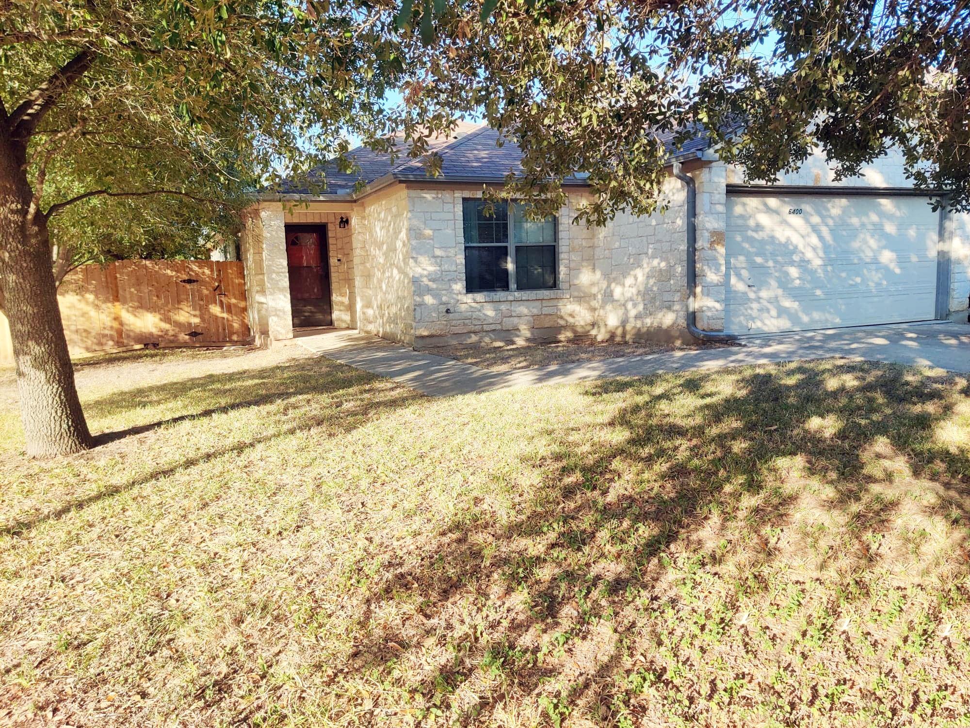Mature trees shade a classic stone exterior with 