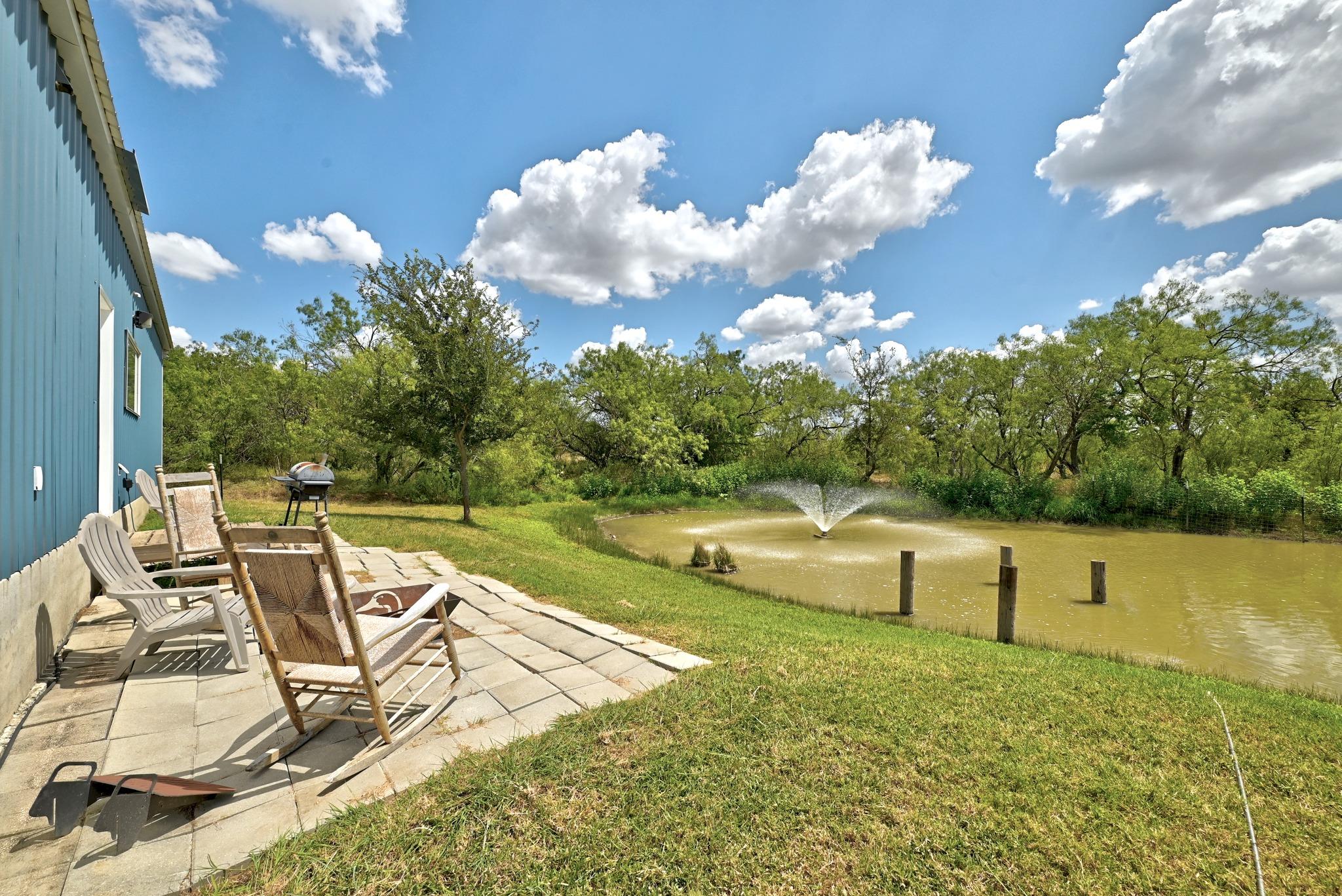 Relaxing stone patio overlooks a scenic pond comp