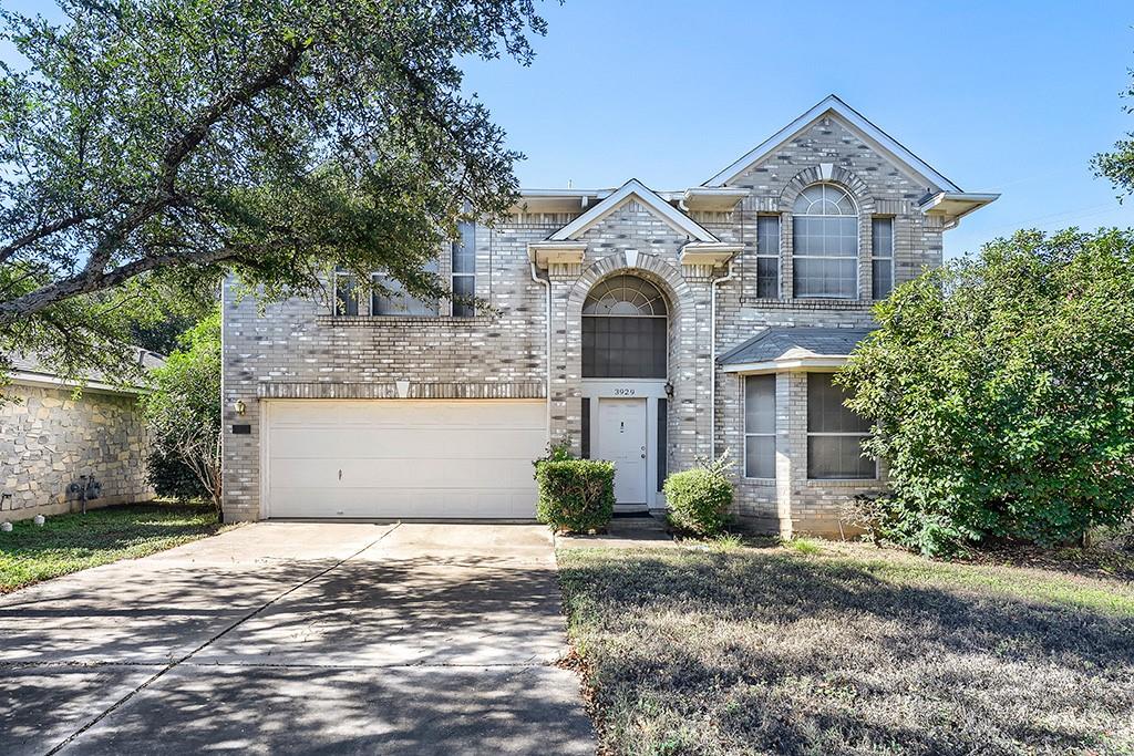 Mature trees frame a classic brick exterior featu
