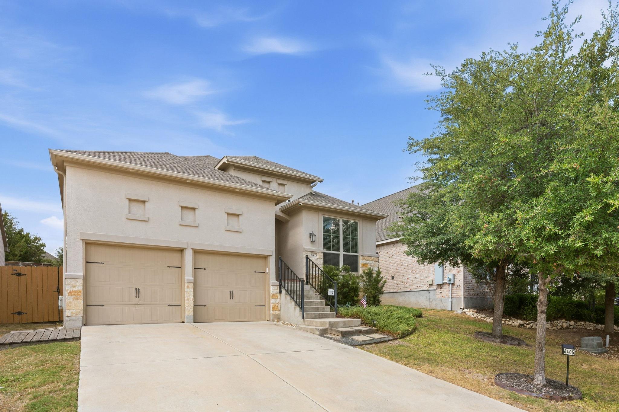 Crisp concrete driveway leads to a modern two-sto