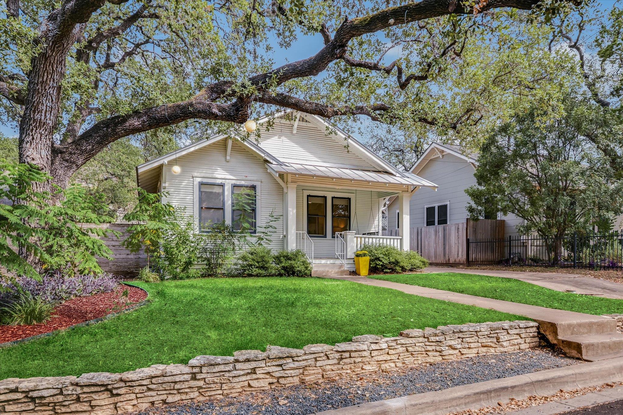 Mature trees shade a welcoming front porch and la