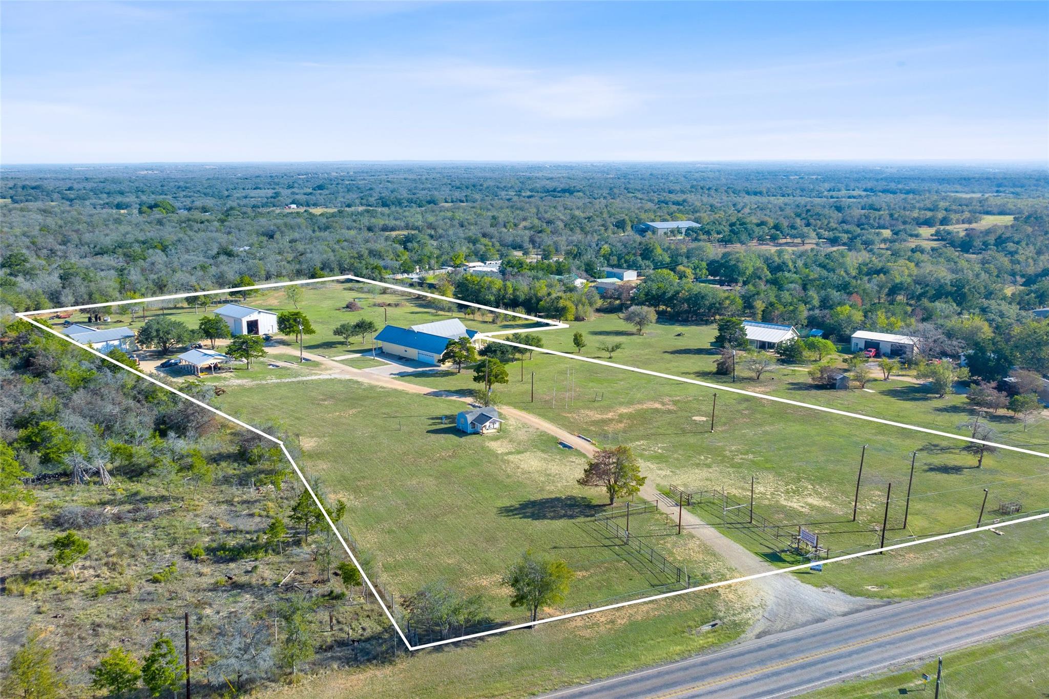 An expansive rural acreage features multiple outb