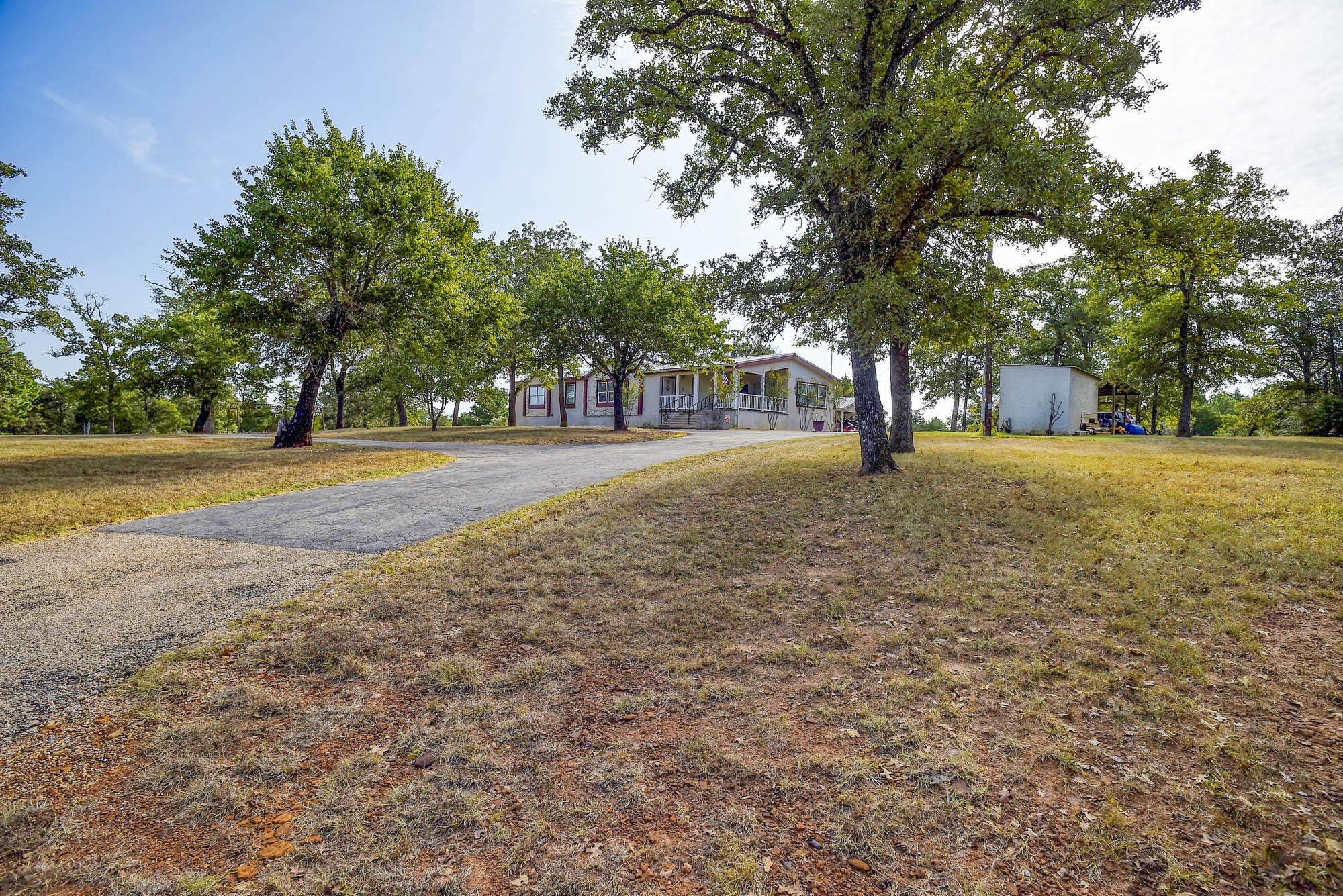 A long paved driveway leads up to the home nestle