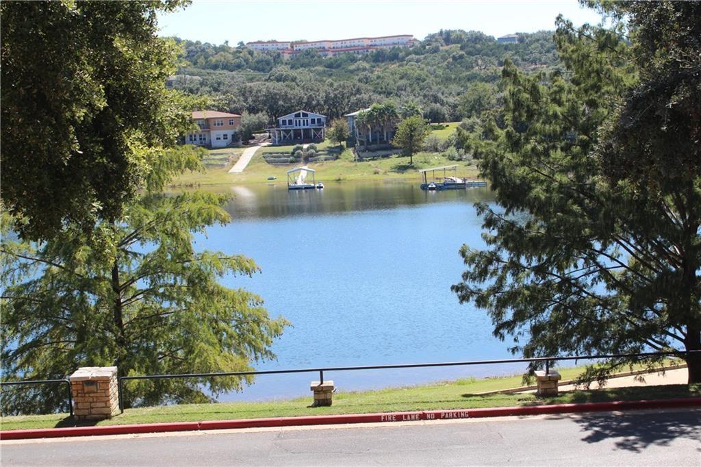 Mature trees frame a quiet lakeside view overlook