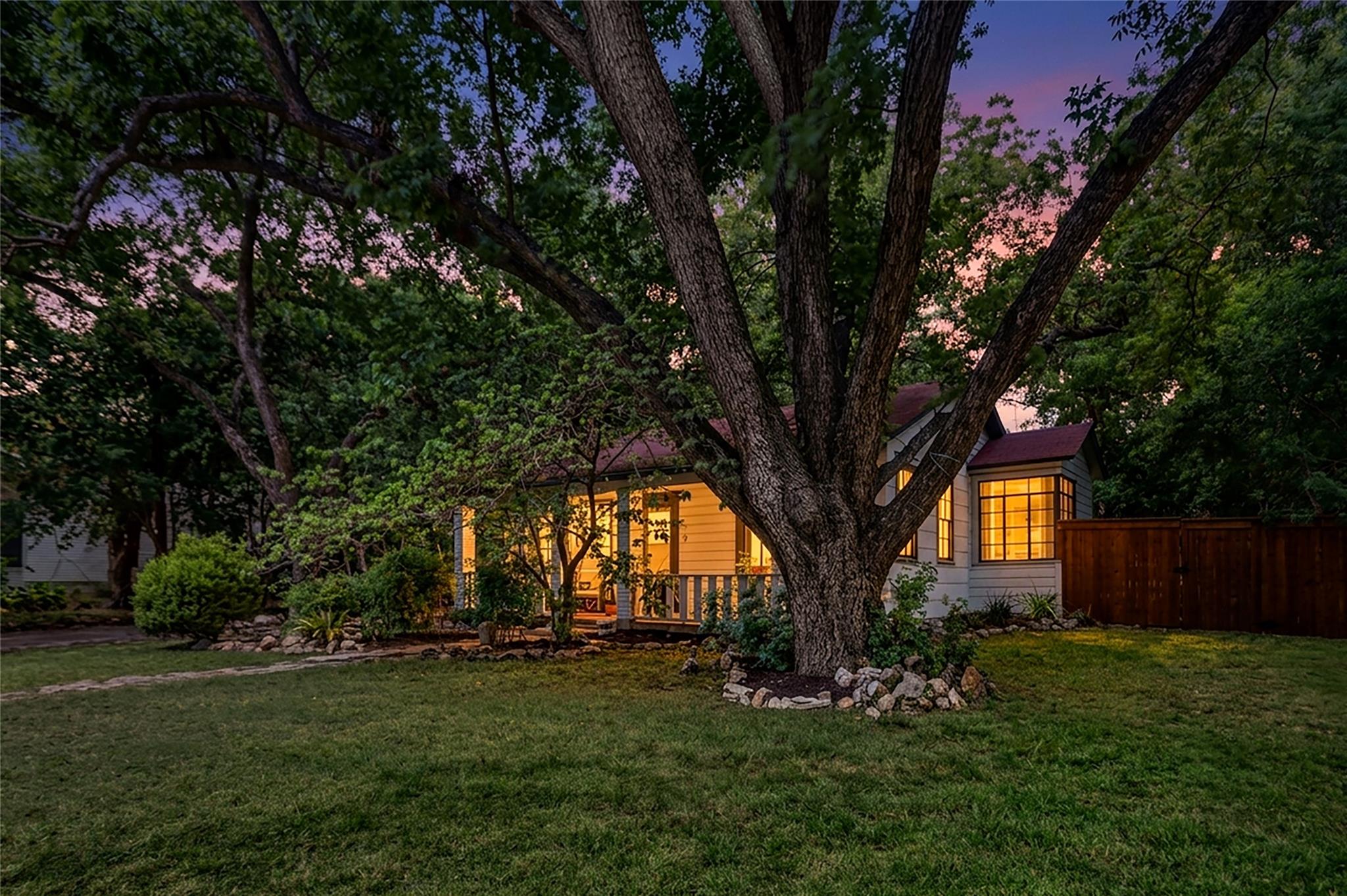 Mature trees frame a charming home nestled in a l