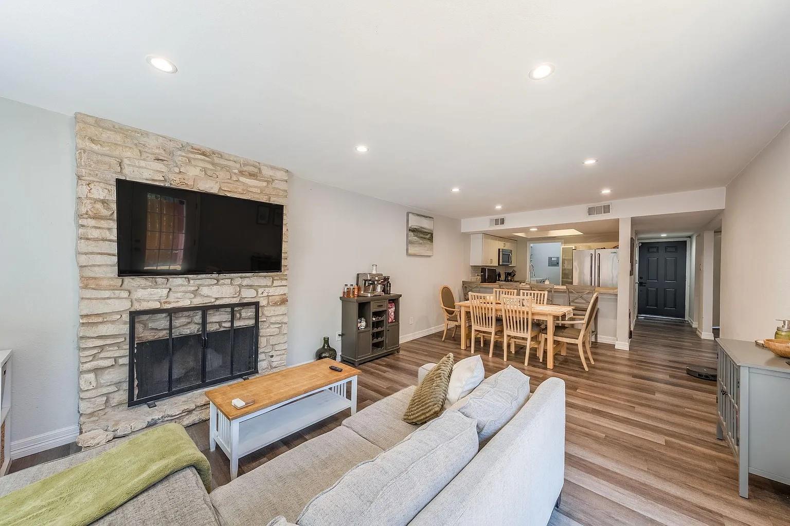 An inviting stone fireplace anchors the seamless,