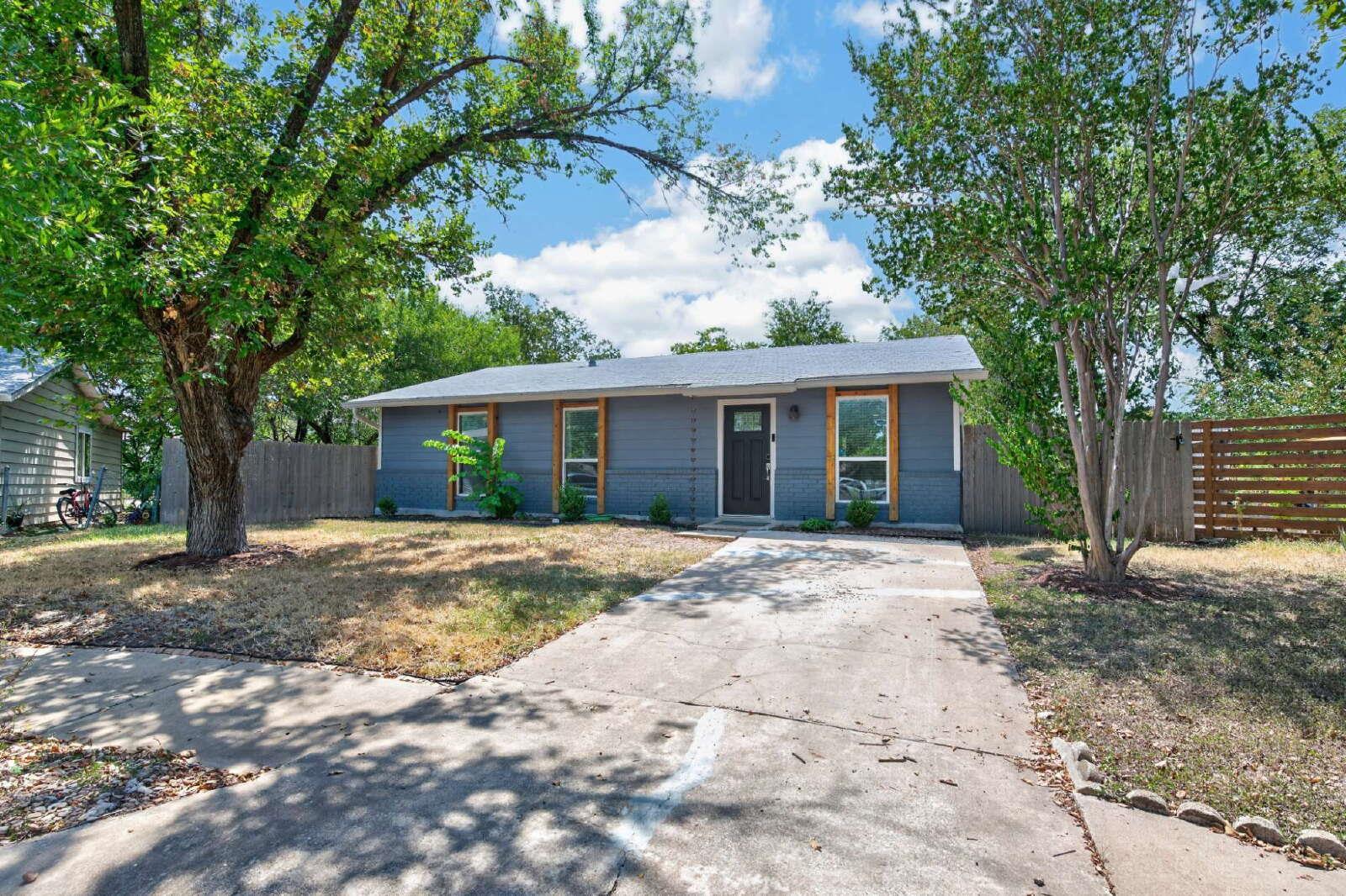 Mature trees shade the front yard and concrete dr