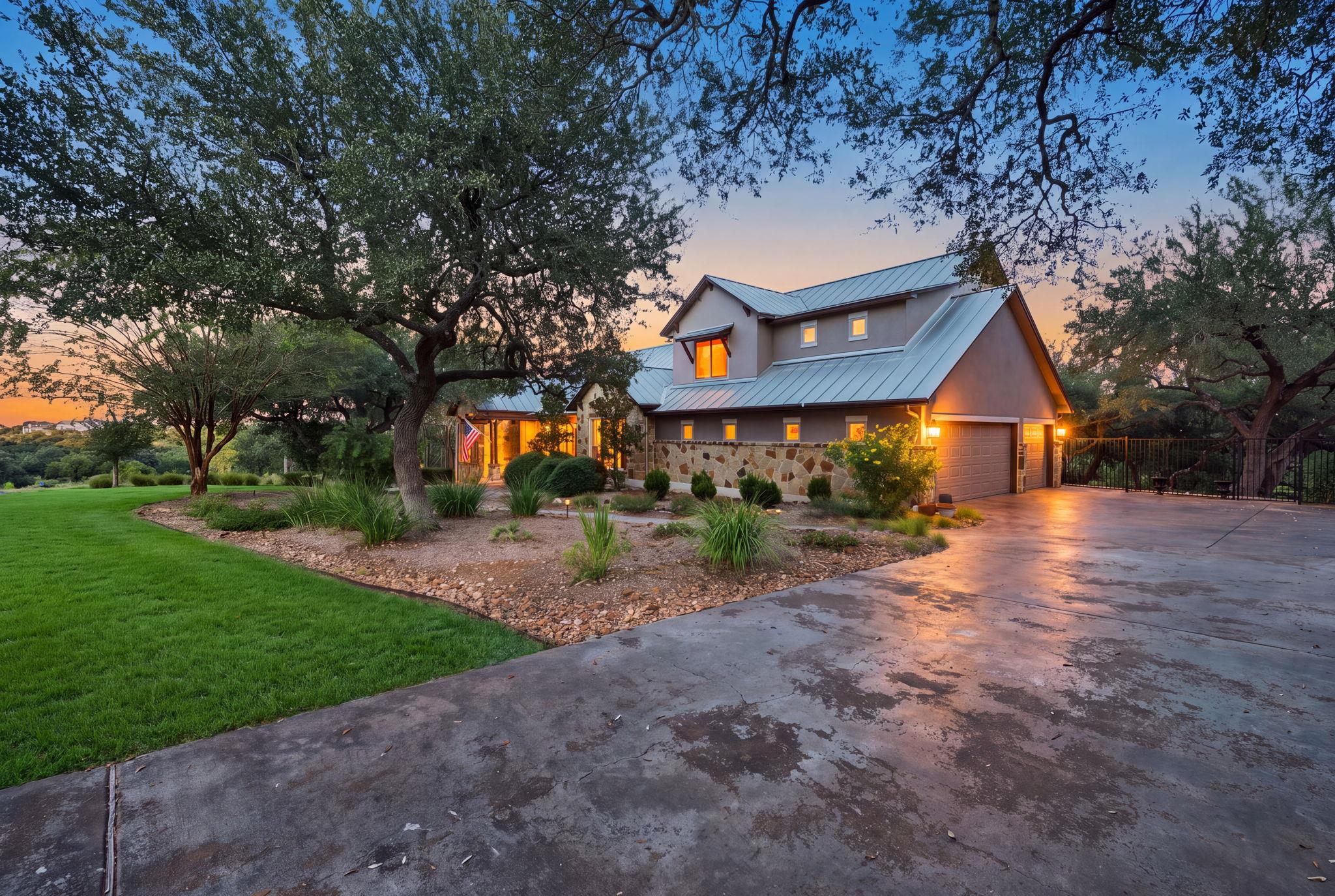 Mature trees and a sweeping driveway frame this c