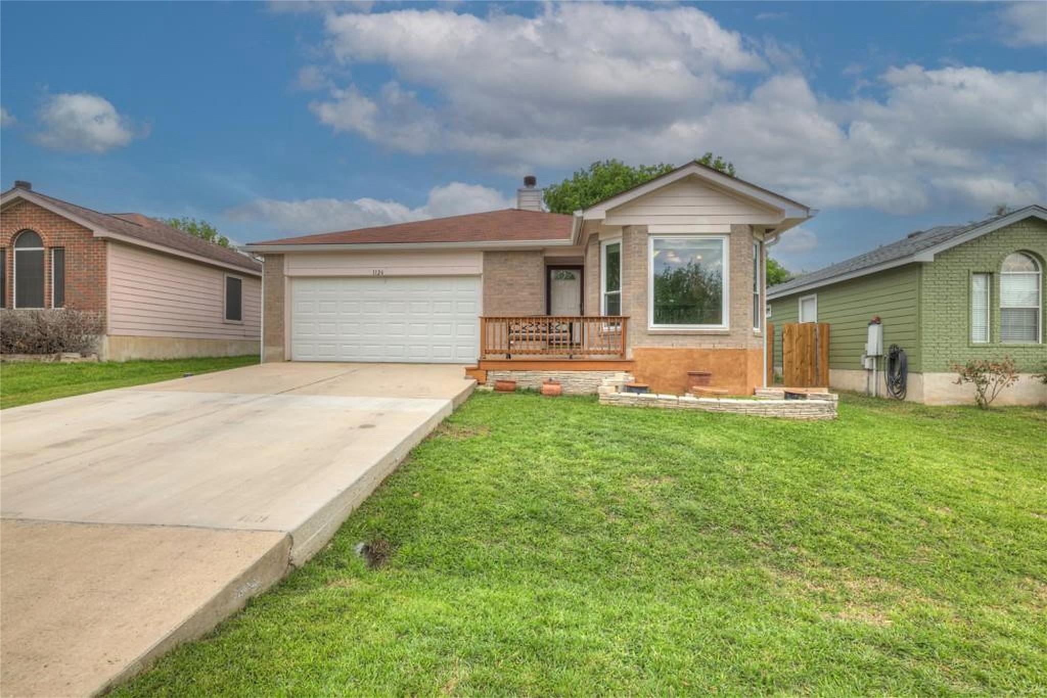 An inviting front porch and a wide concrete drive