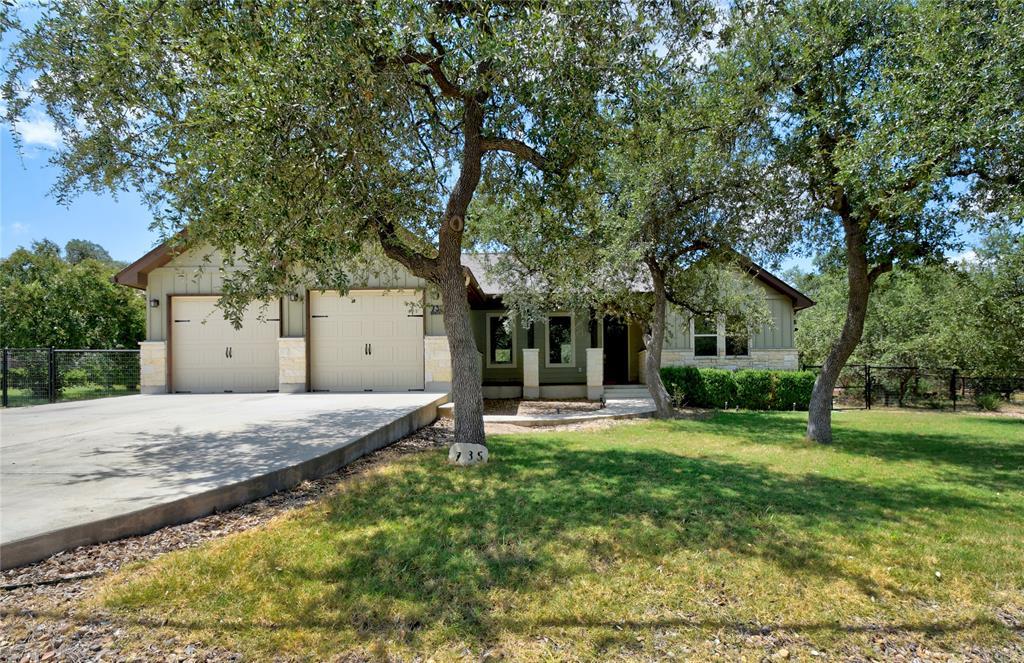 Mature shade trees frame a charming single-story 
