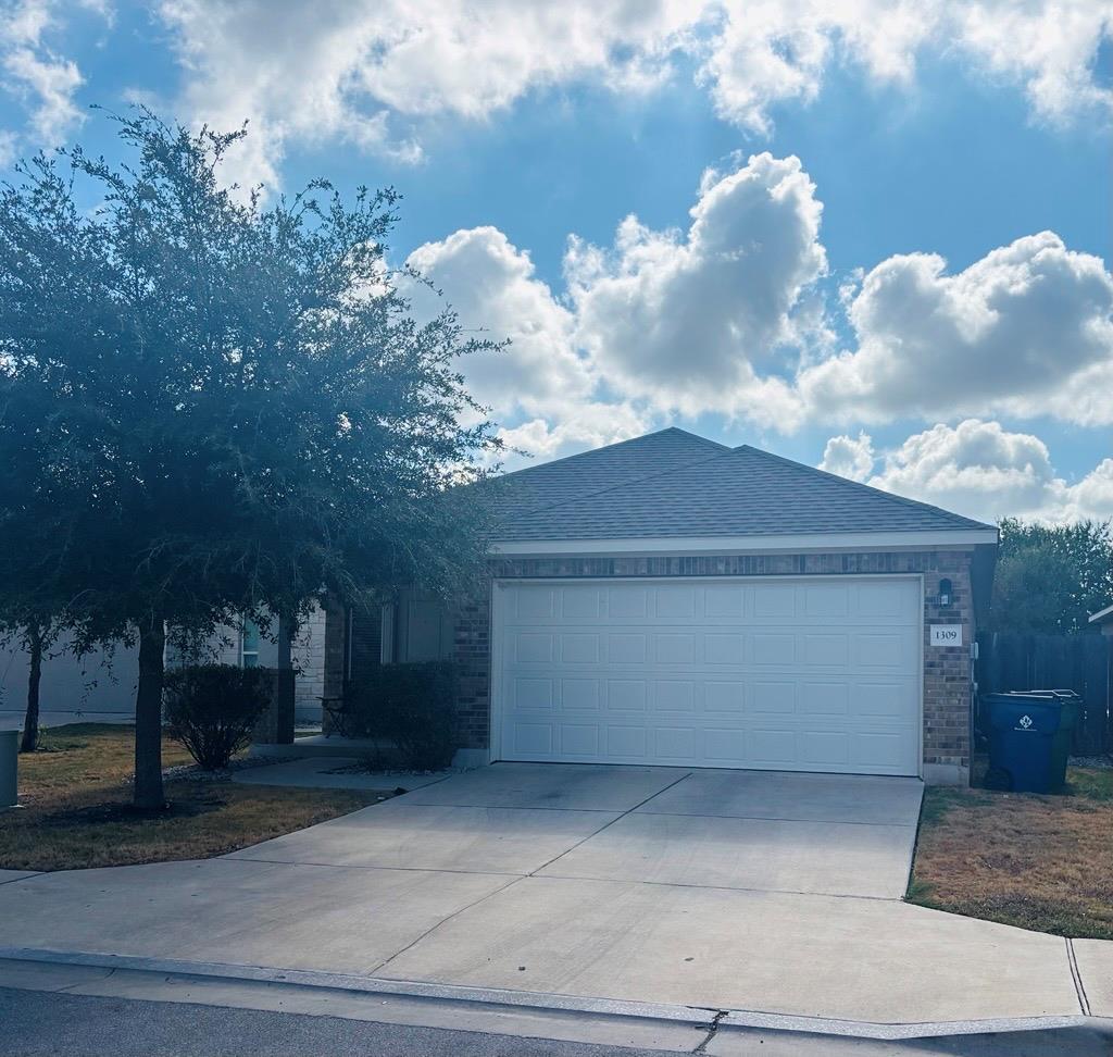 A spacious concrete driveway leads to the attache