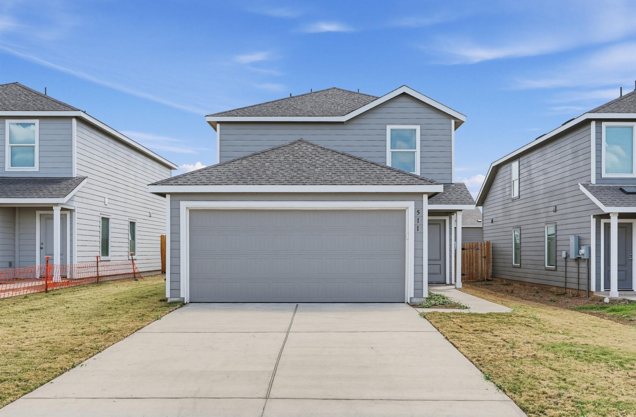 A wide concrete driveway leads directly to the at