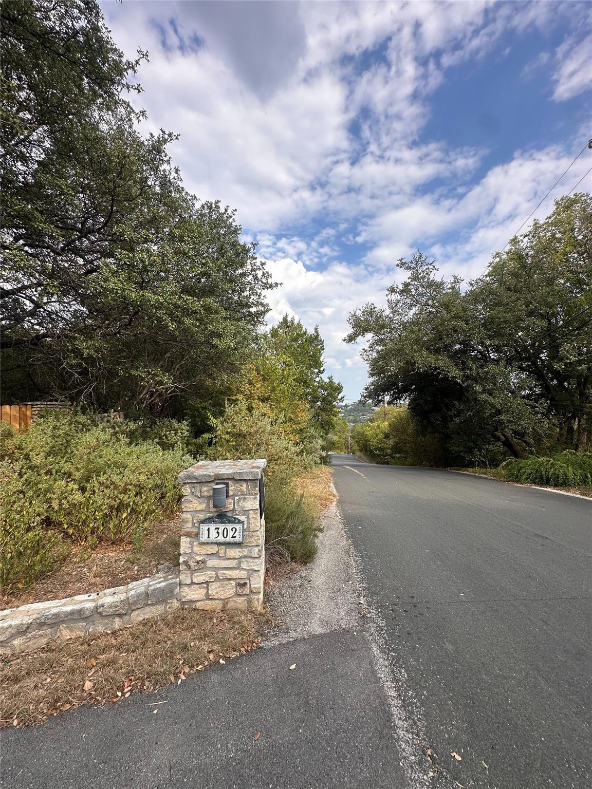 Mature trees frame a quiet neighborhood street le