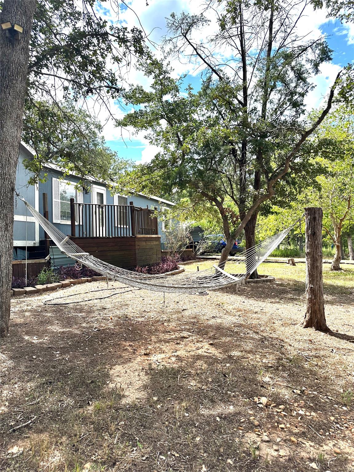 Mature trees shade a peaceful yard featuring an e