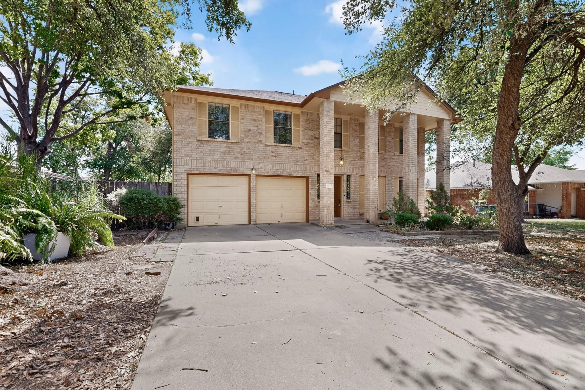 Stately brick columns and a long concrete drivewa
