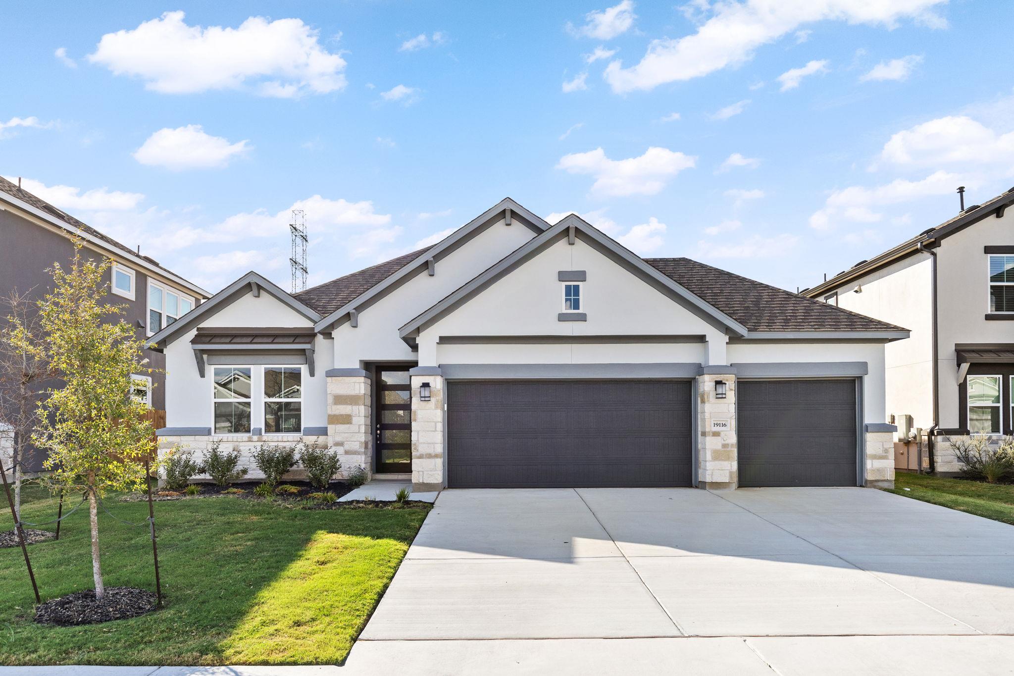 A spacious concrete driveway leads to the modern 