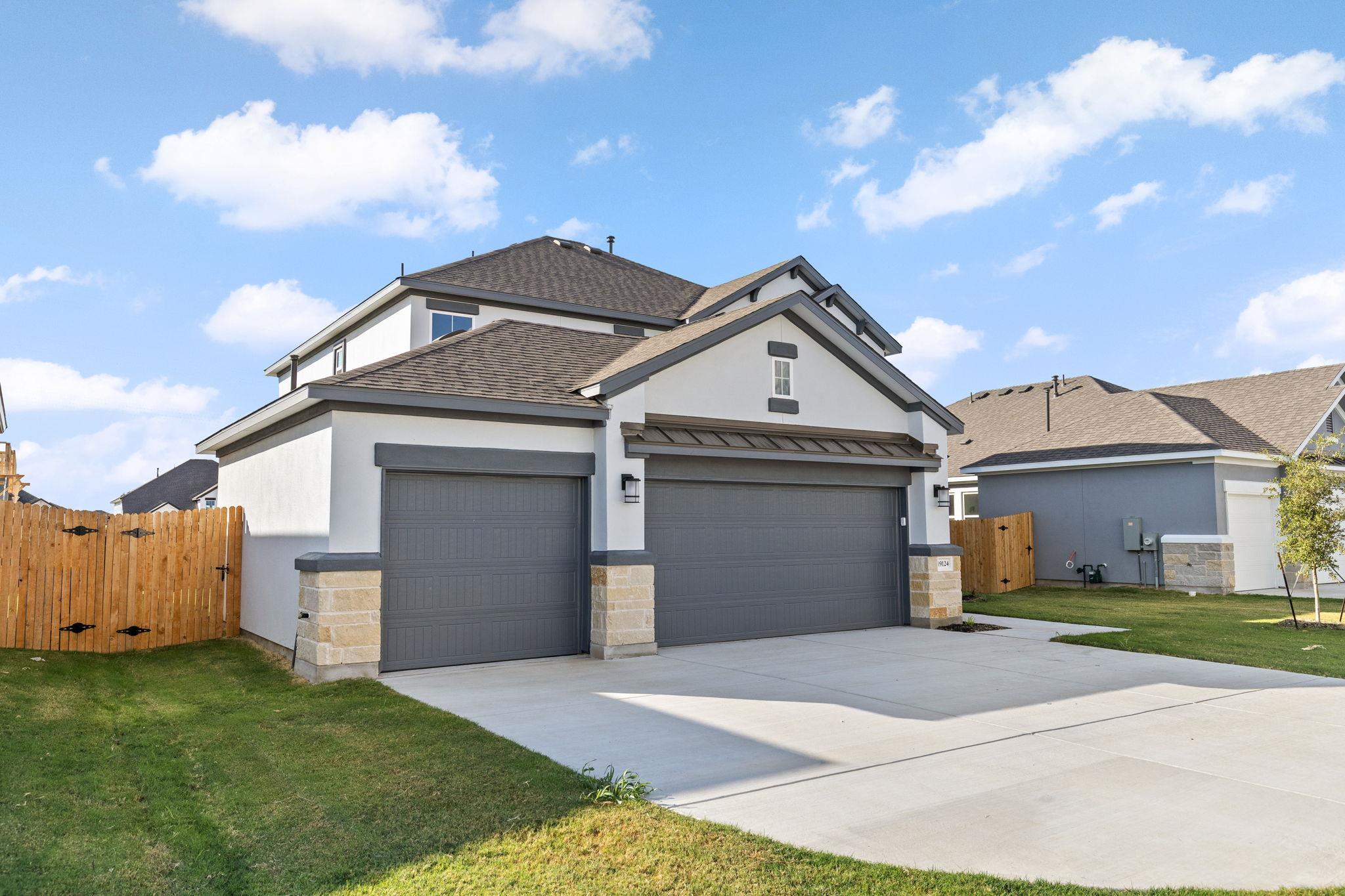 A spacious concrete driveway leads to a modern th