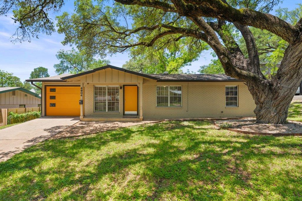 Mature oak trees shade a charming brick exterior 