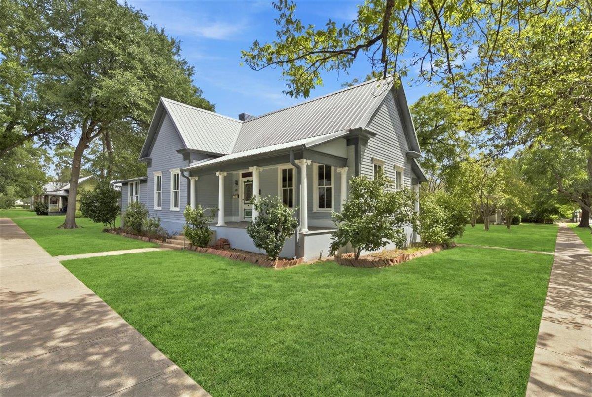 Crisp lap siding and a durable metal roof define 