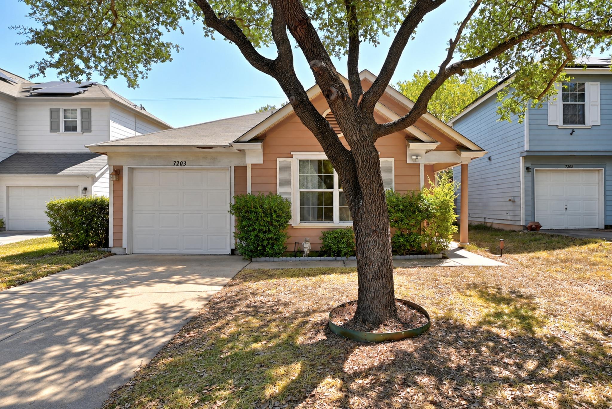 Mature shade trees and clean exterior lines defin