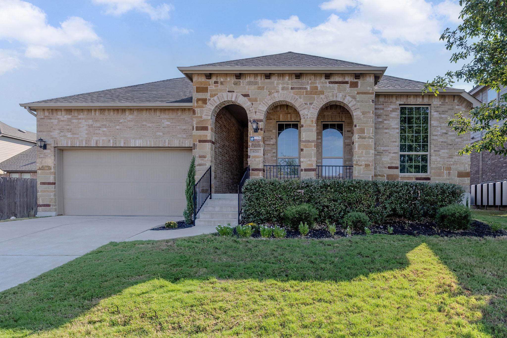 Arched entryways and natural stone detailing elev