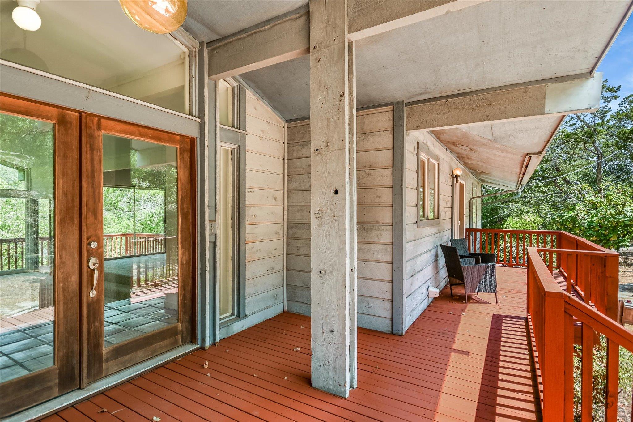 An inviting covered wood deck features rustic sid