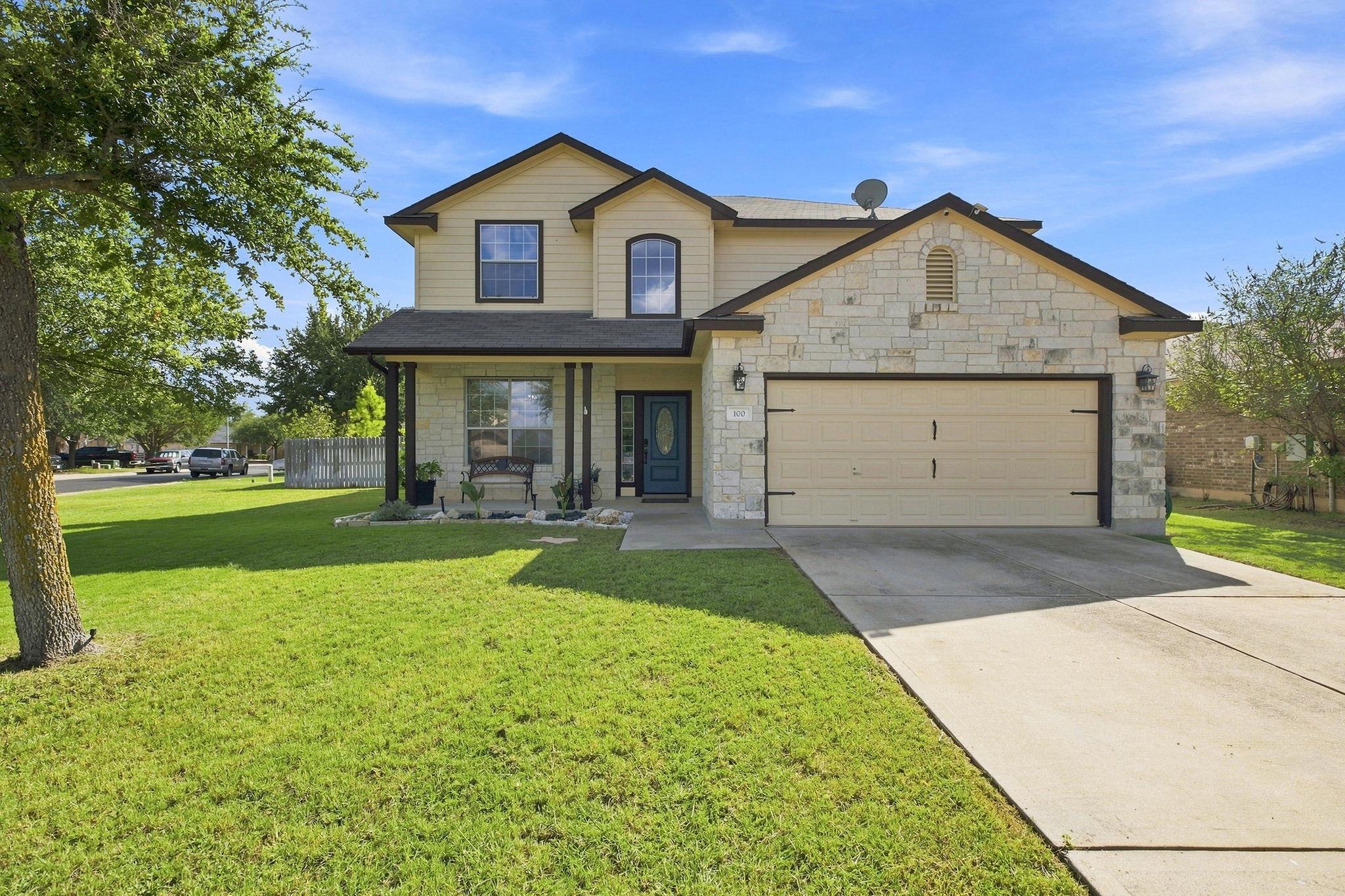 A classic two-story exterior features a stone fac
