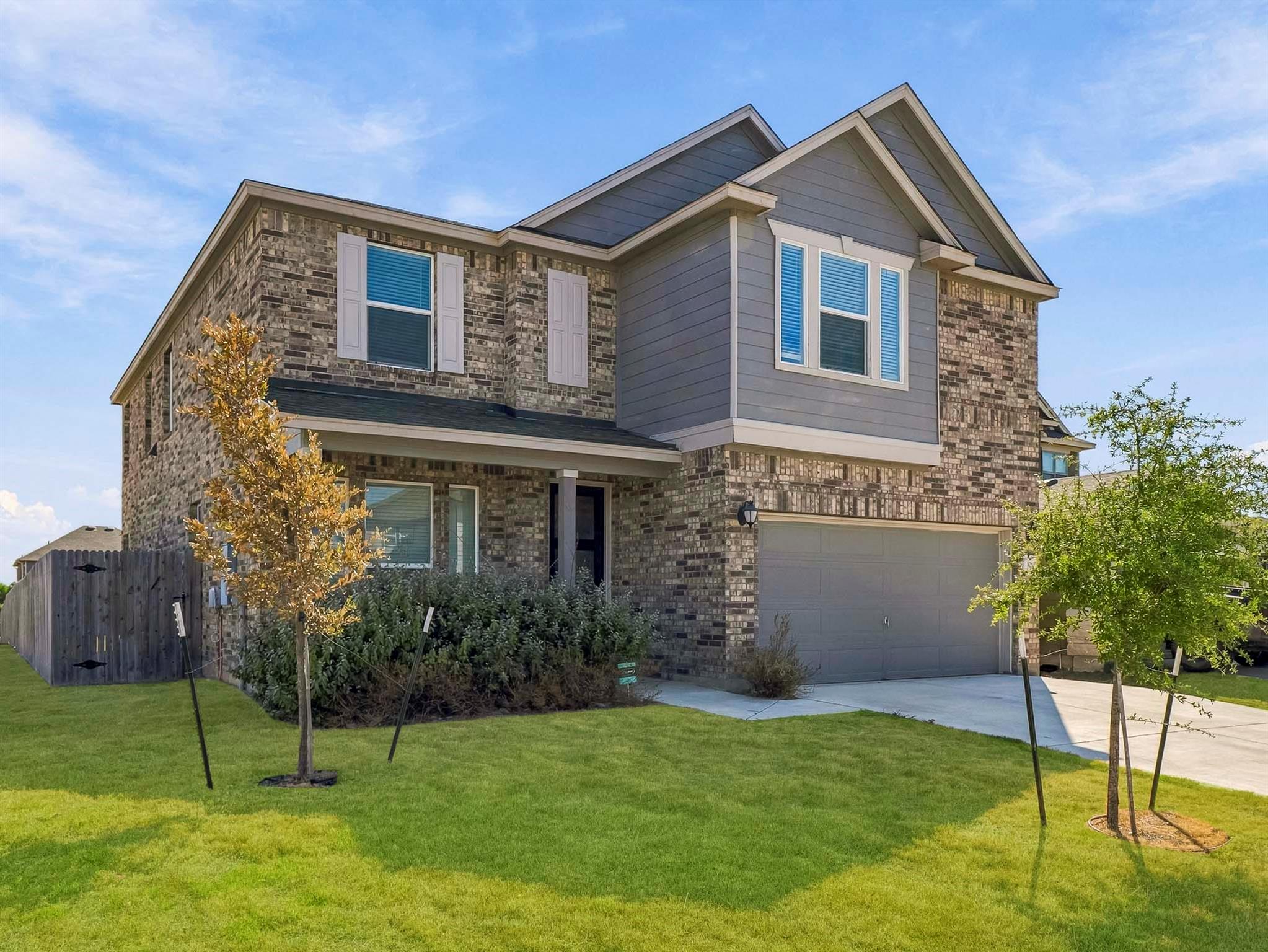 A classic brick exterior and manicured lawn creat
