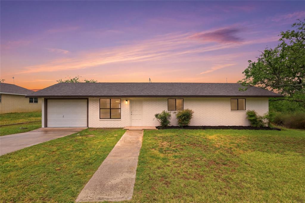 A classic brick exterior and a concrete pathway d