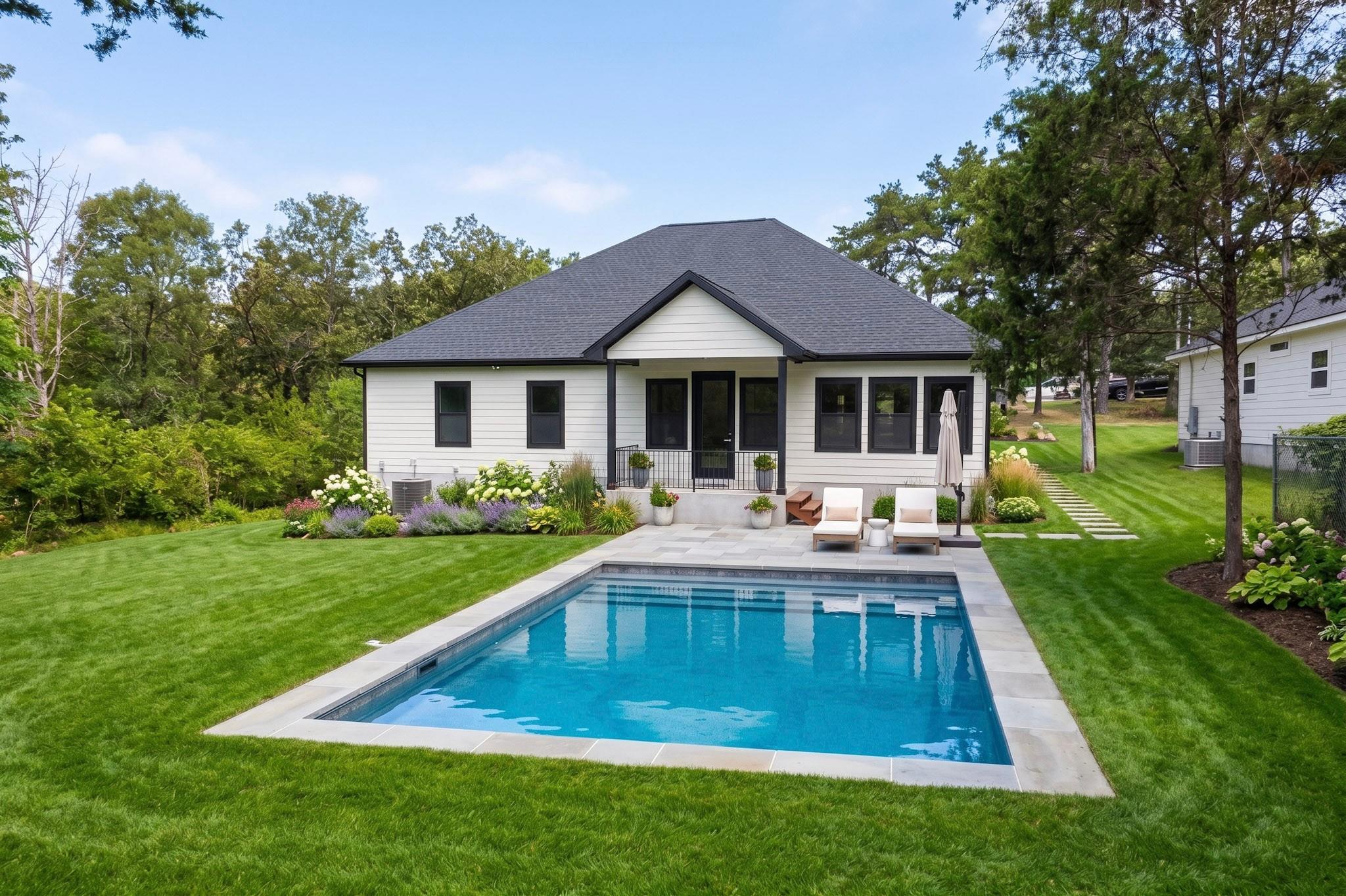 Lush green lawns surround an inviting backyard sw