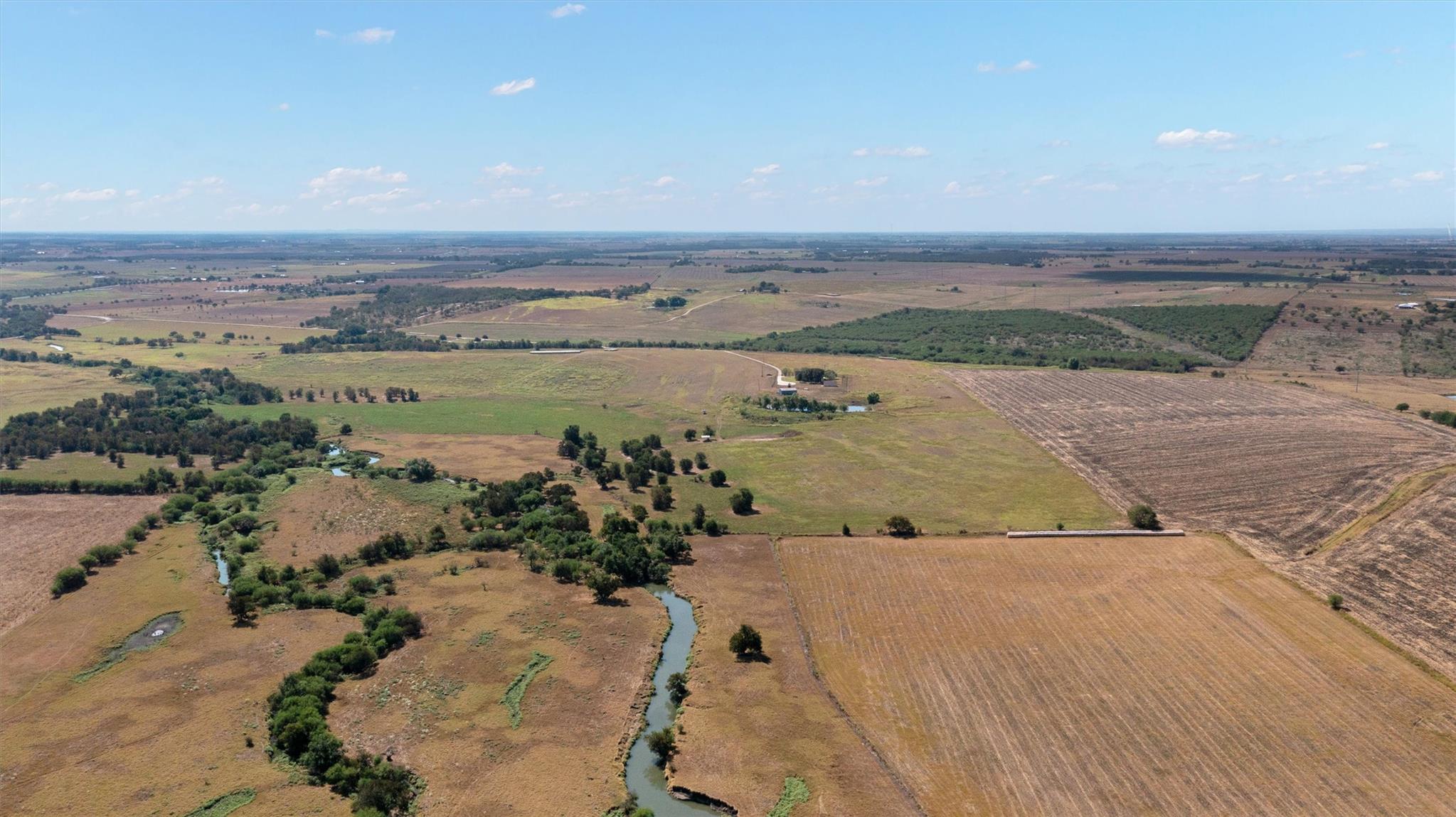 Rolling countryside and a winding creek stretch a