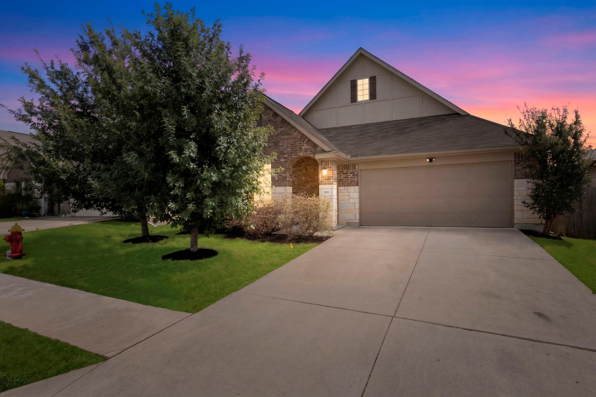 A spacious driveway leads to this classic brick a