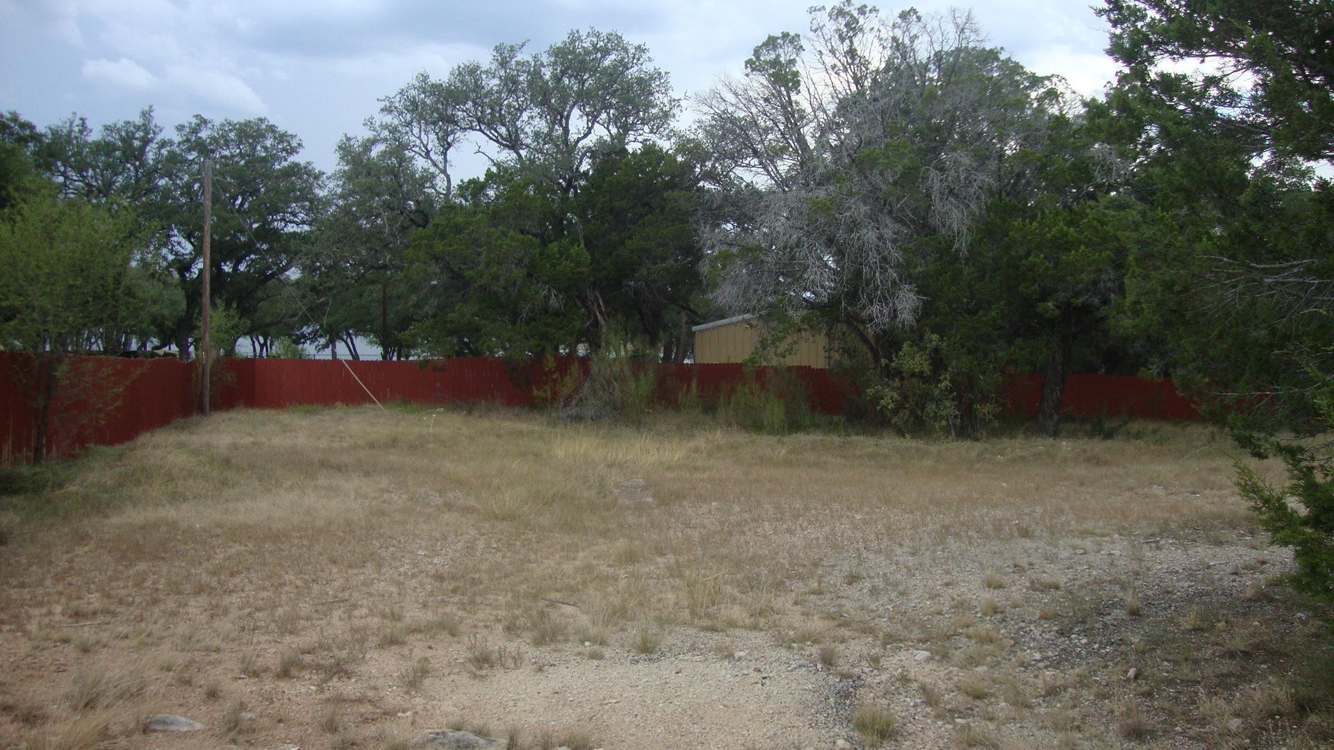 Mature trees frame a spacious, fenced backyard of