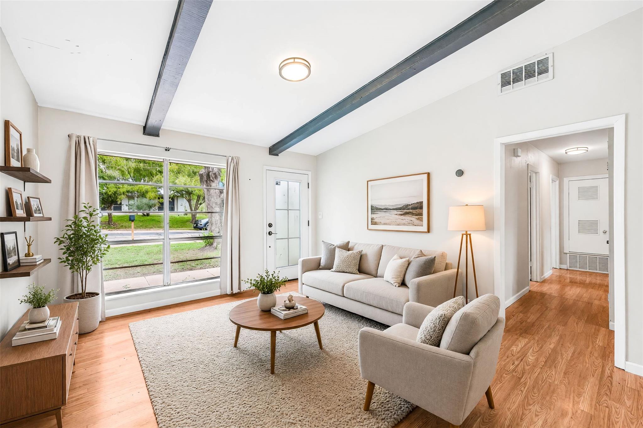 Exposed ceiling beams and rich wood flooring anch