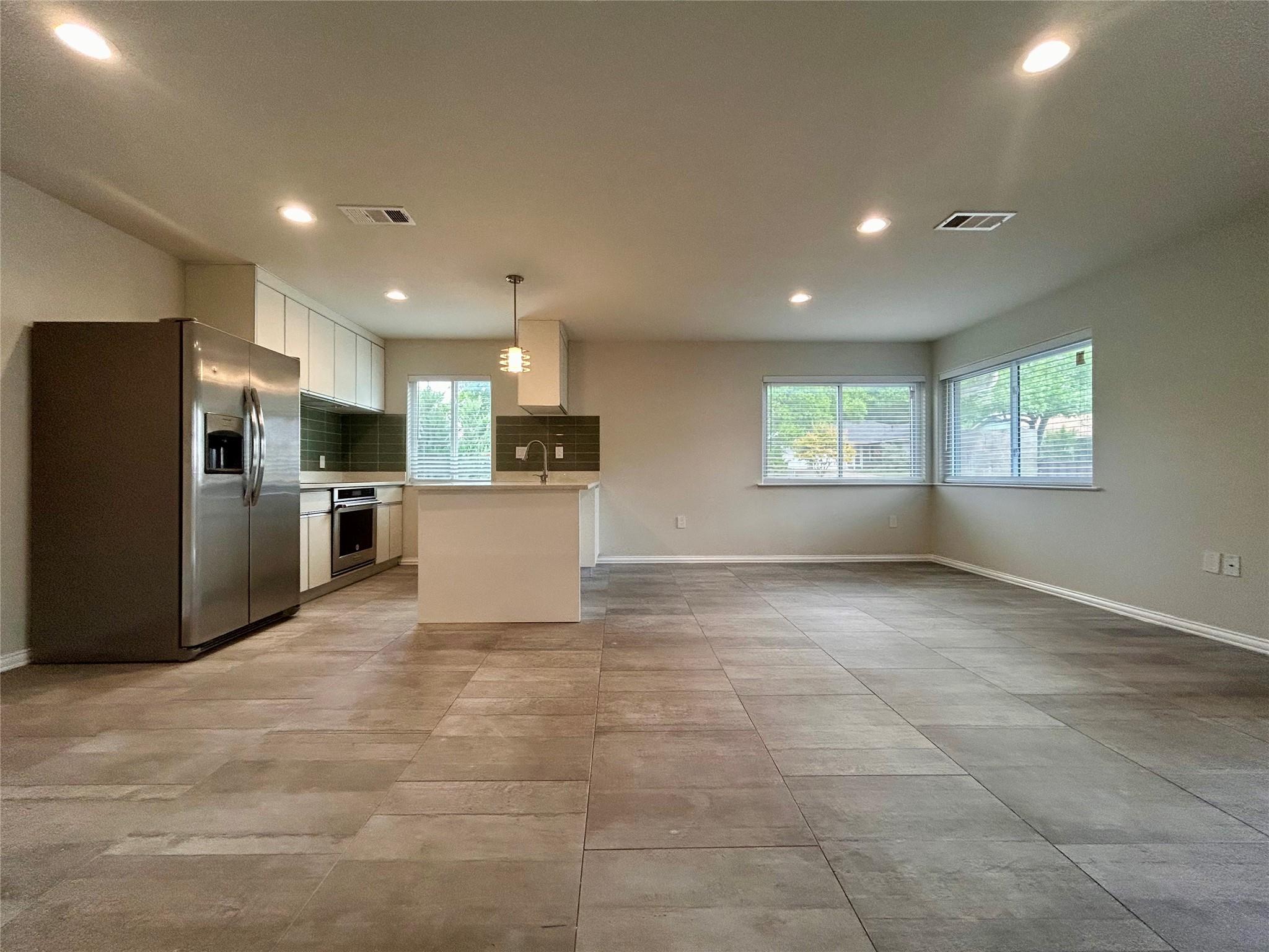Tile flooring and recessed lighting span this ope