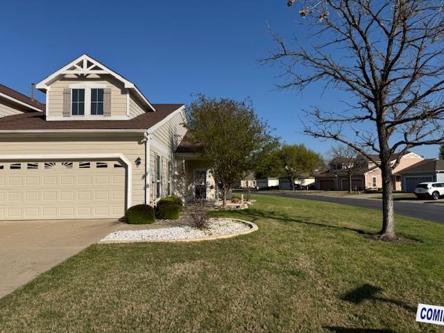 View of front of house with a front yard, drivewa