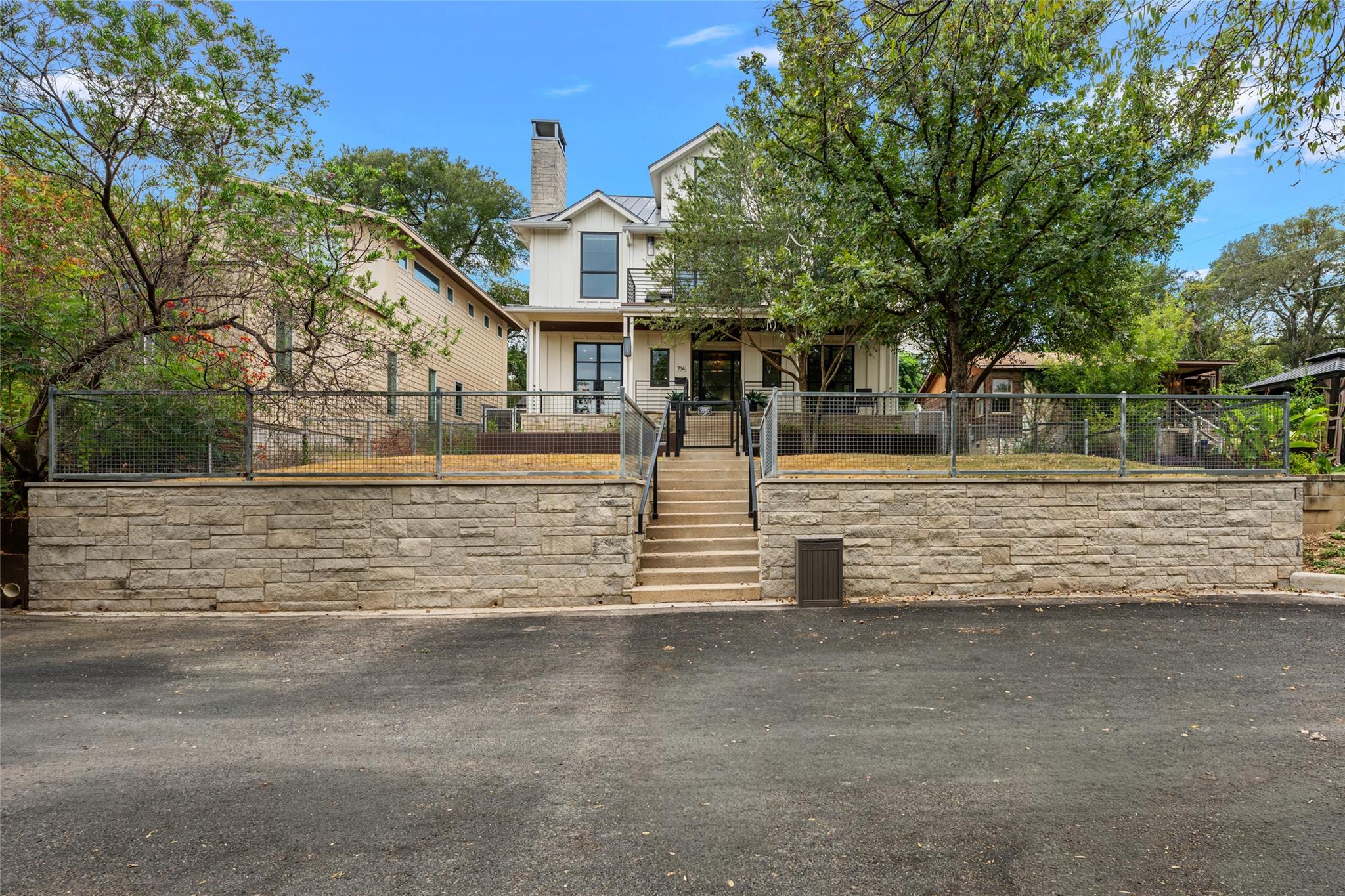 An elevated stone retaining wall and metal fencin