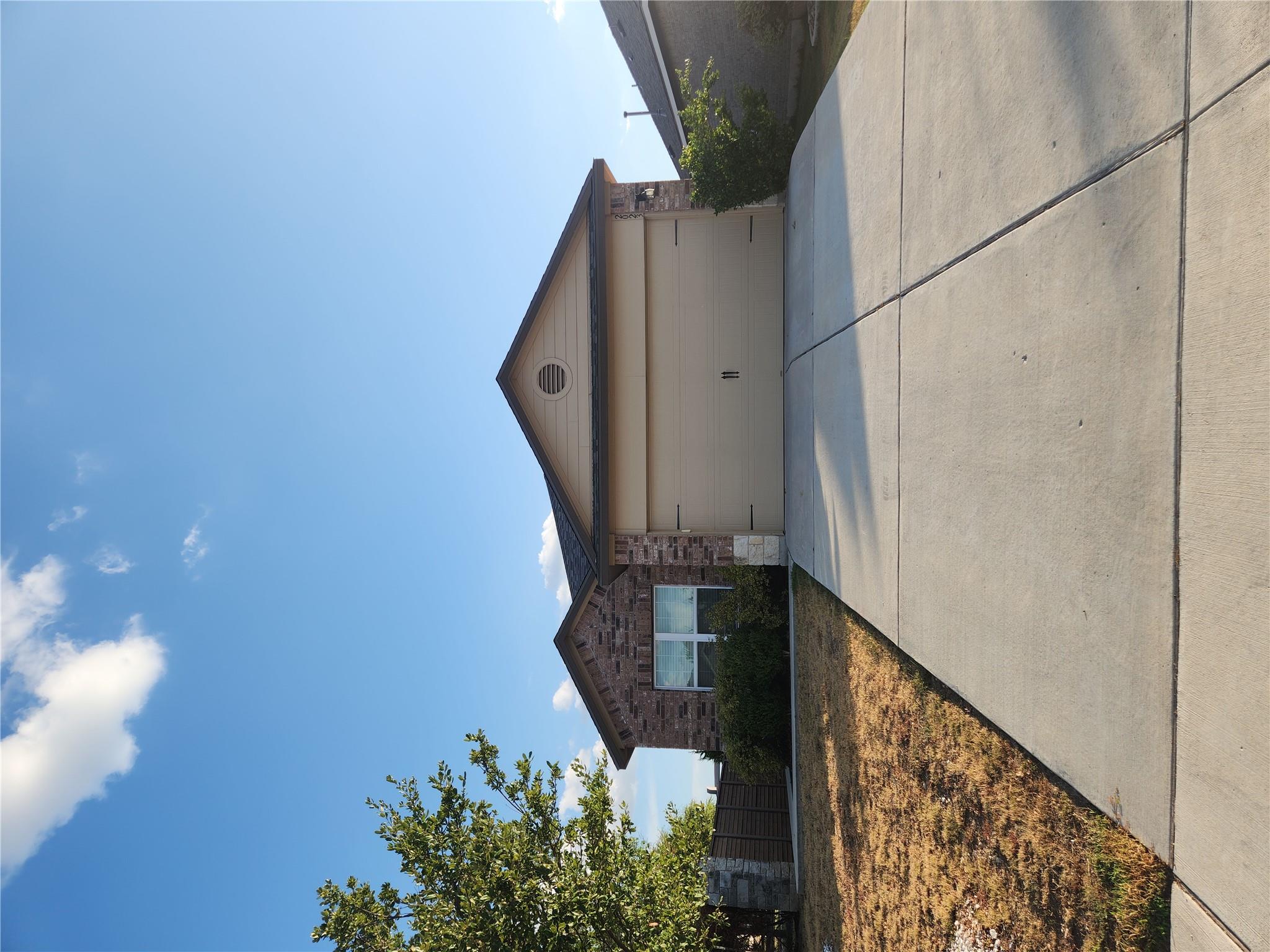 A wide concrete driveway leads straight to the at