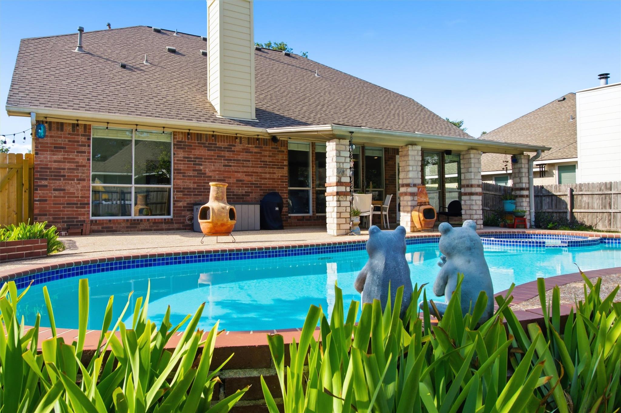 An inviting backyard pool accents this classic br