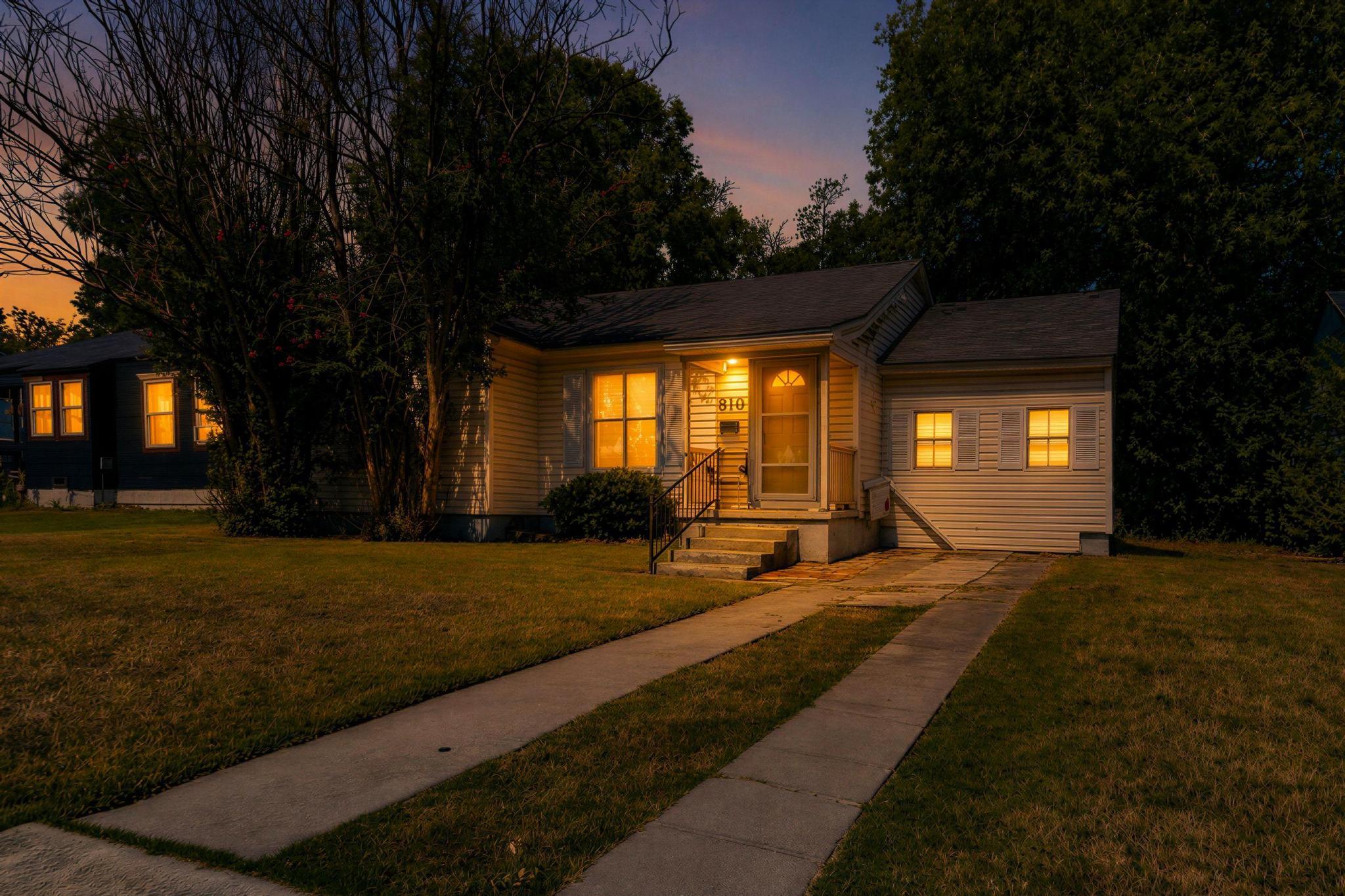 A welcoming front porch and concrete driveway def