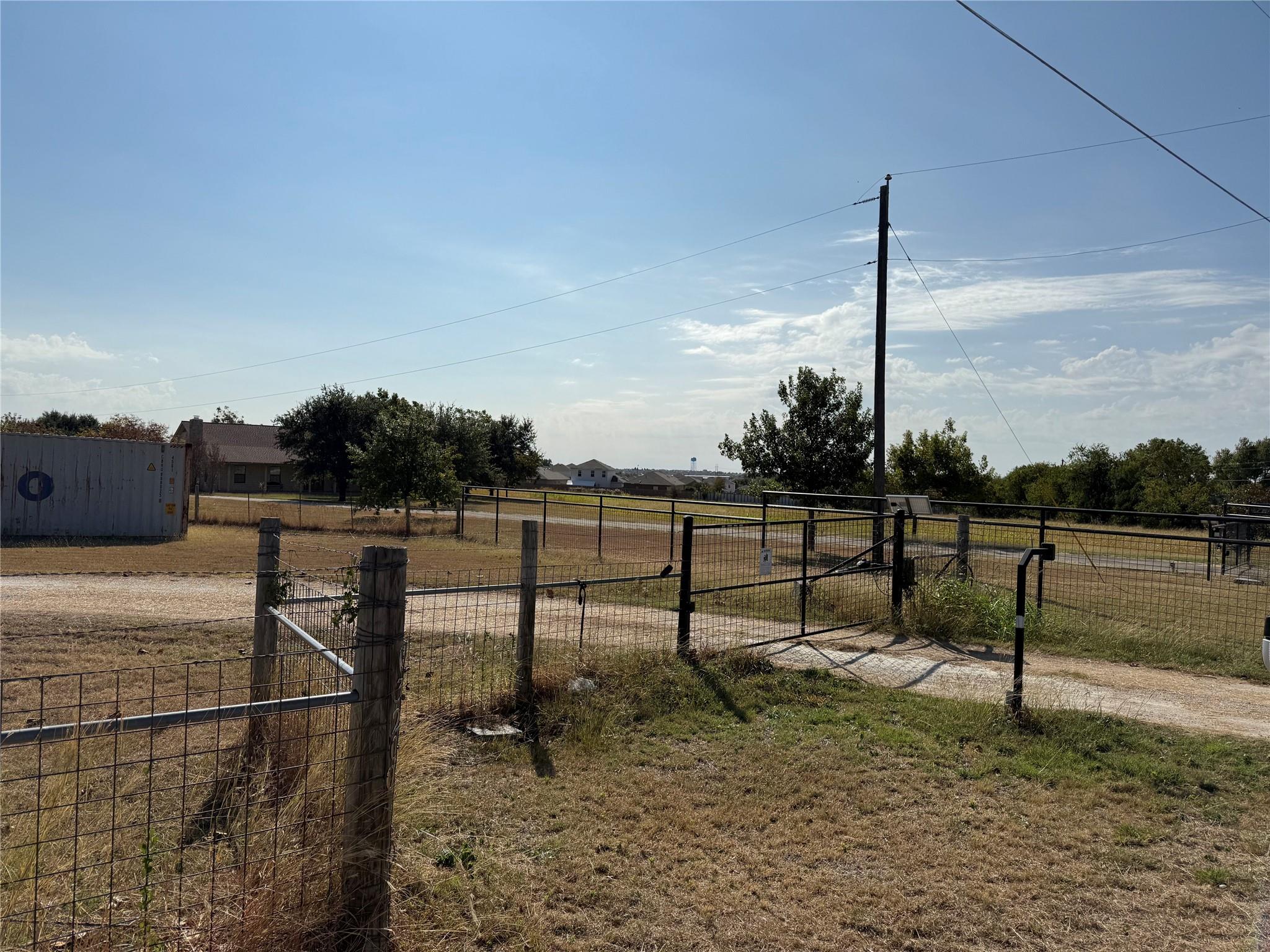 Fenced pastures and a gated gravel driveway defin