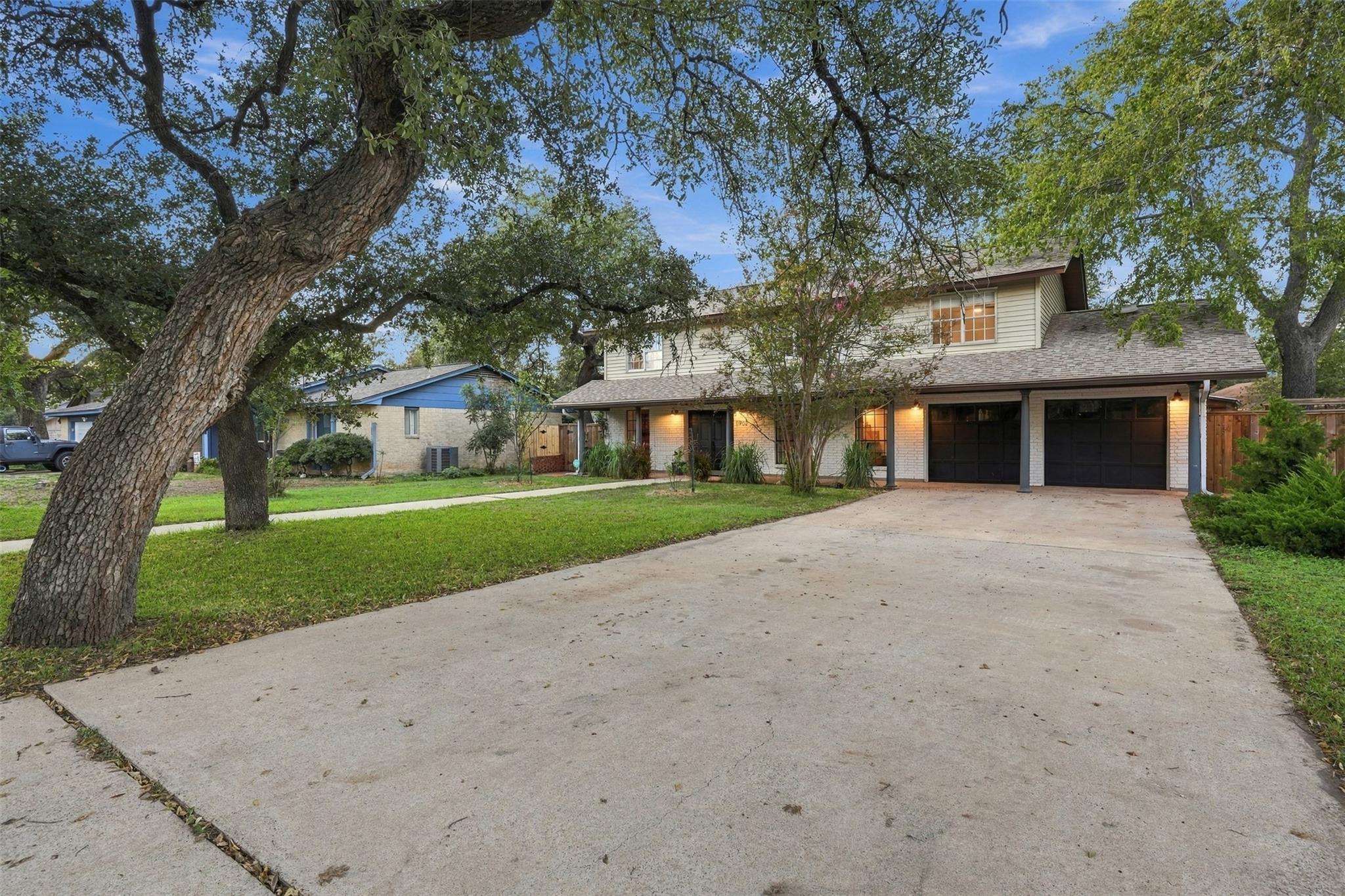 Mature trees frame a welcoming facade complete wi
