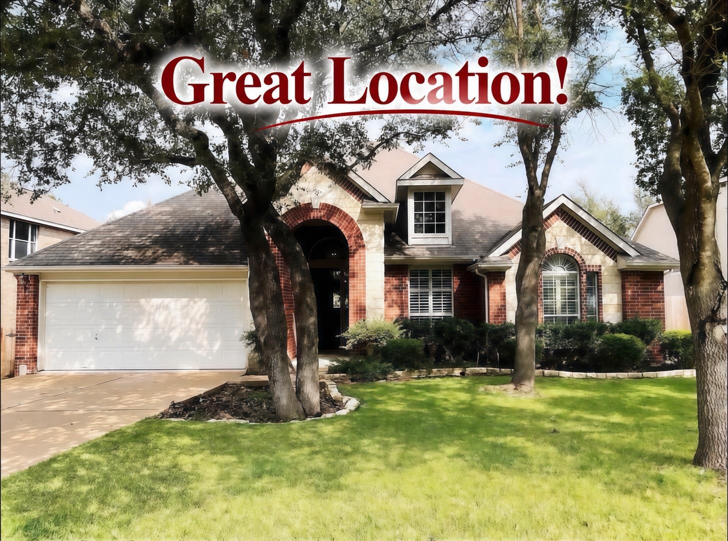 Mature trees shade a classic brick facade with an